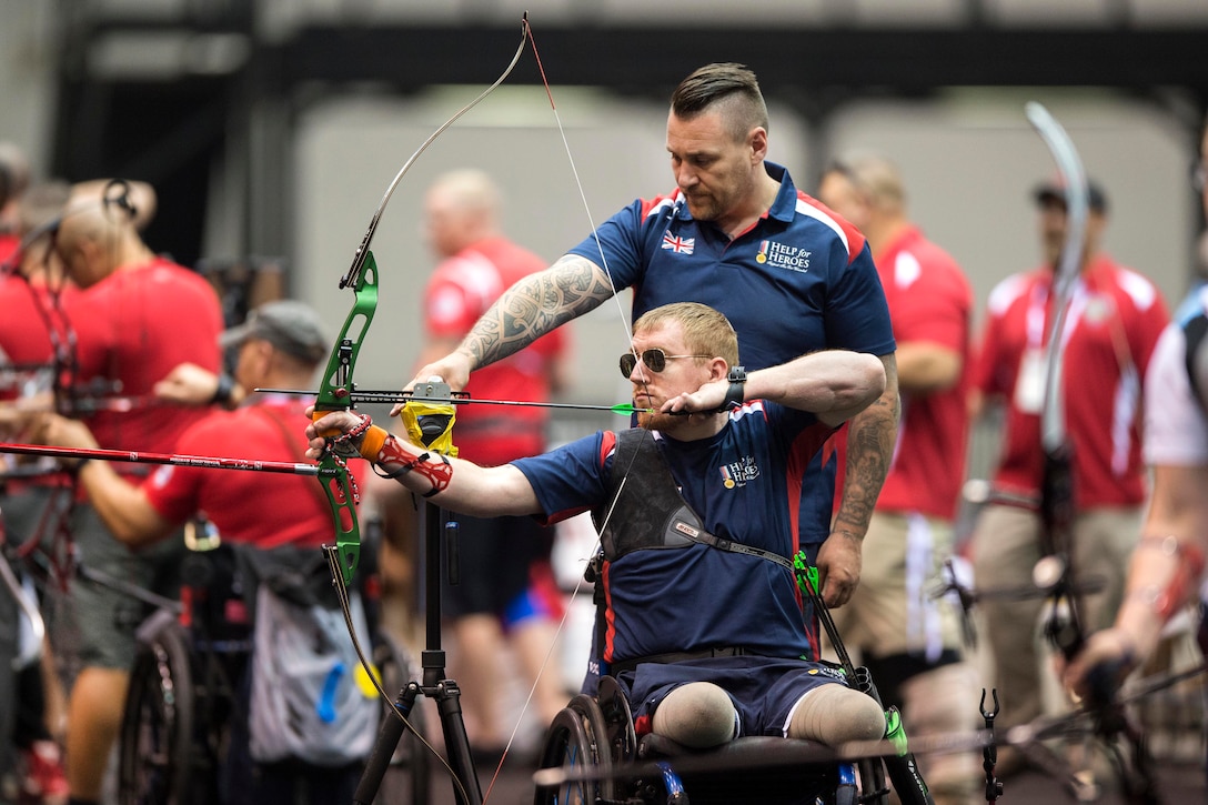 British army veteran Kingsman Anthony Cooper, who is visually impaired, lines up an archery shot with a helper during practice for the 2017 Department of Defense Warrior Games in Chicago, June 29, 2017. DoD photo by EJ Hersom