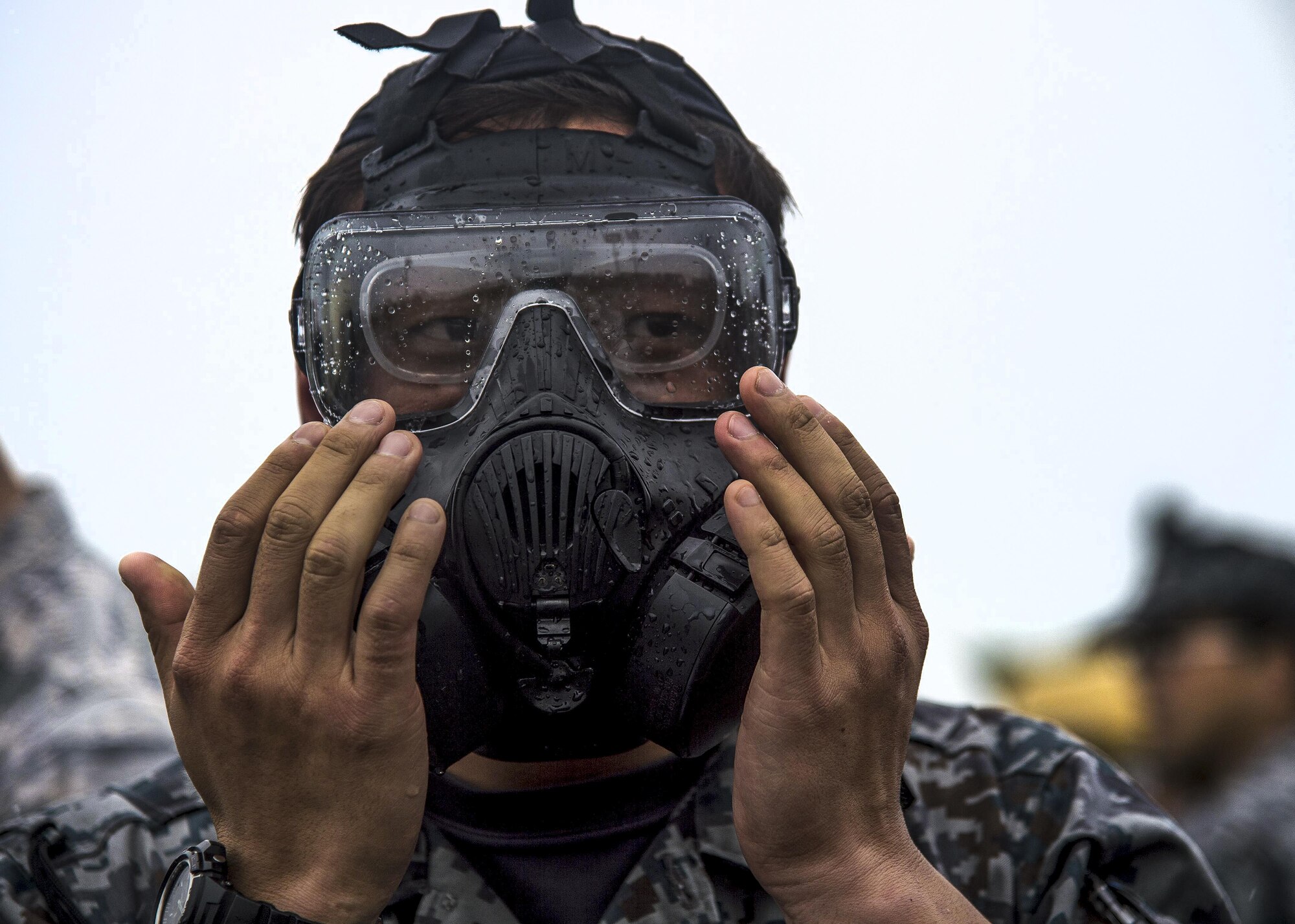 A Japan Air Self-Defense Force civil engineer airman tries on an M50 gas mask during a bilateral exchange event at Misawa Air Base, Japan, June 21, 2017. Building friendships and enhancing mutual understanding were also vital pieces in this Pacific unity event. After long days of training, U.S. and Japanese CE airmen put on civilian clothes and hosted informal dinners to promote international partnerships. (U.S. Air Force photo/Senior Airman Deana Heitzman)