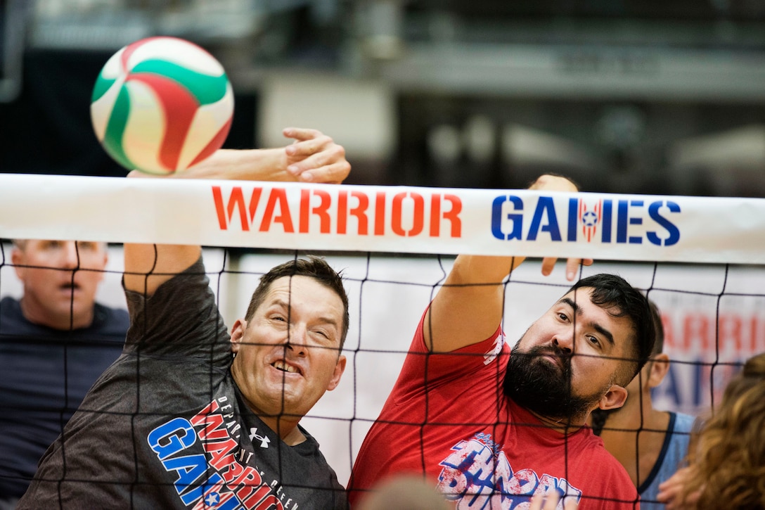 Army Sgt. 1st Class Douglas Norman, left, and veteran Staff Sgt. Jason Wakefield return a ball during sitting volleyball practice for the 2017 Department of Defense Warrior Games in Chicago, June 29, 2017. Norman and Wakefield are assigned to Special Operations Command. DoD photo by Roger L. Wollenberg