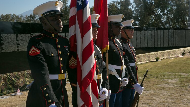 Marines with the Headquarters Battalion Color Guard prepare to present the colors during the opening program of the Moving Vietnam Veteran Memorial Wall at Mission Springs Park in Desert Hot Springs, Calif., June 22, 2017. The Moving Wall, a scale model of the original Vietnam Veterans Memorial Wall, has the names of those men and women who were killed or missing in action etched onto a reflective stone, so visitors can not only see the names, but see themselves, reflecting on the lives of the people who fought and died to keep them safe. (U.S. Marine Corps photo by Cpl. Dave Flores)