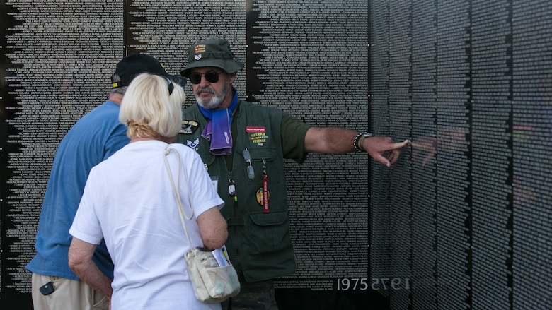 Retired Air Force Staff Sgt. Dennis Blessman speaks to visitors about the Moving Vietnam Veteran Memorial Wall after the opening program at Mission Springs Park in Desert Hot Springs, Calif., June 22, 2017 The Moving Wall, a scale model of the original Vietnam Veterans Memorial Wall, has the names of those men and women who were killed or missing in action etched onto a reflective stone, so visitors can not only see the names, but see themselves, reflecting on the lives of the people who fought and died to keep them safe. (U.S. Marine Corps photo by Cpl. Dave Flores)