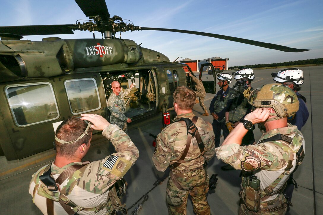 New Jersey Army National Guard Sgt. Timothy Witts, center, briefs airmen and civilian responders on the hoist system for a UH-60 Black Hawk medevac helicopter at Joint Base McGuire-Dix-Lakehurst, N.J., June 28, 2017. Witts is a crew chief.  The training was part of New Jersey Task Force One, which provides advanced technical search and rescue capabilities and includes New Jersey National Guard soldiers and airmen, as well as civilians. Air National Guard photo by Master Sgt. Matt Hecht
