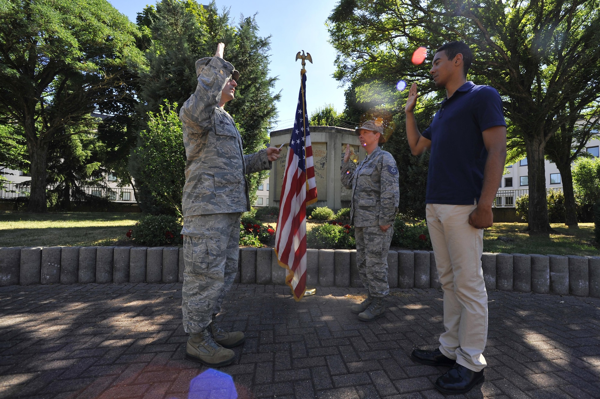 U.S. Air Force Lt. Col. Steven Brummitt, 86th Communications Squadron commander, administers the oath of enlistment to U.S. Air Force Tech. Sgt. Jamee Dean, 86th Communications Squadron communication focal point section chief, and her son Shandon Dean at the Berlin Wall Memorial at the Ramstein Officer’s Club, Ramstein Air Base, June 26, 2017. Colleagues, friends, and family members attended the brief ceremony allowing Tech. Sgt. Dean to reenlist at the same time her son enlists in the Air Force.  (U.S. Air Force photo by Airman 1st Class D. Blake Browning)