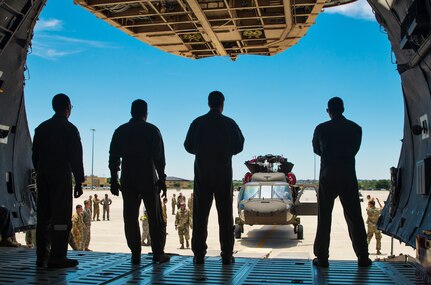 Loadmasters from the 68th Airlift Squadron watch as a UH-60 Black Hawk helicopter is towed to the ramp of a C-5M Super Galaxy aircraft June 22, 2017 at Joint Base San Antonio-Lackland. Operation Silver Galaxy was a five-day training event that featured Airmen training Soldiers on properly securing their aircraft for a deployment in the cargo area of a C-5M Super Galaxy. (U.S. Air Force photo by Benjamin Faske)