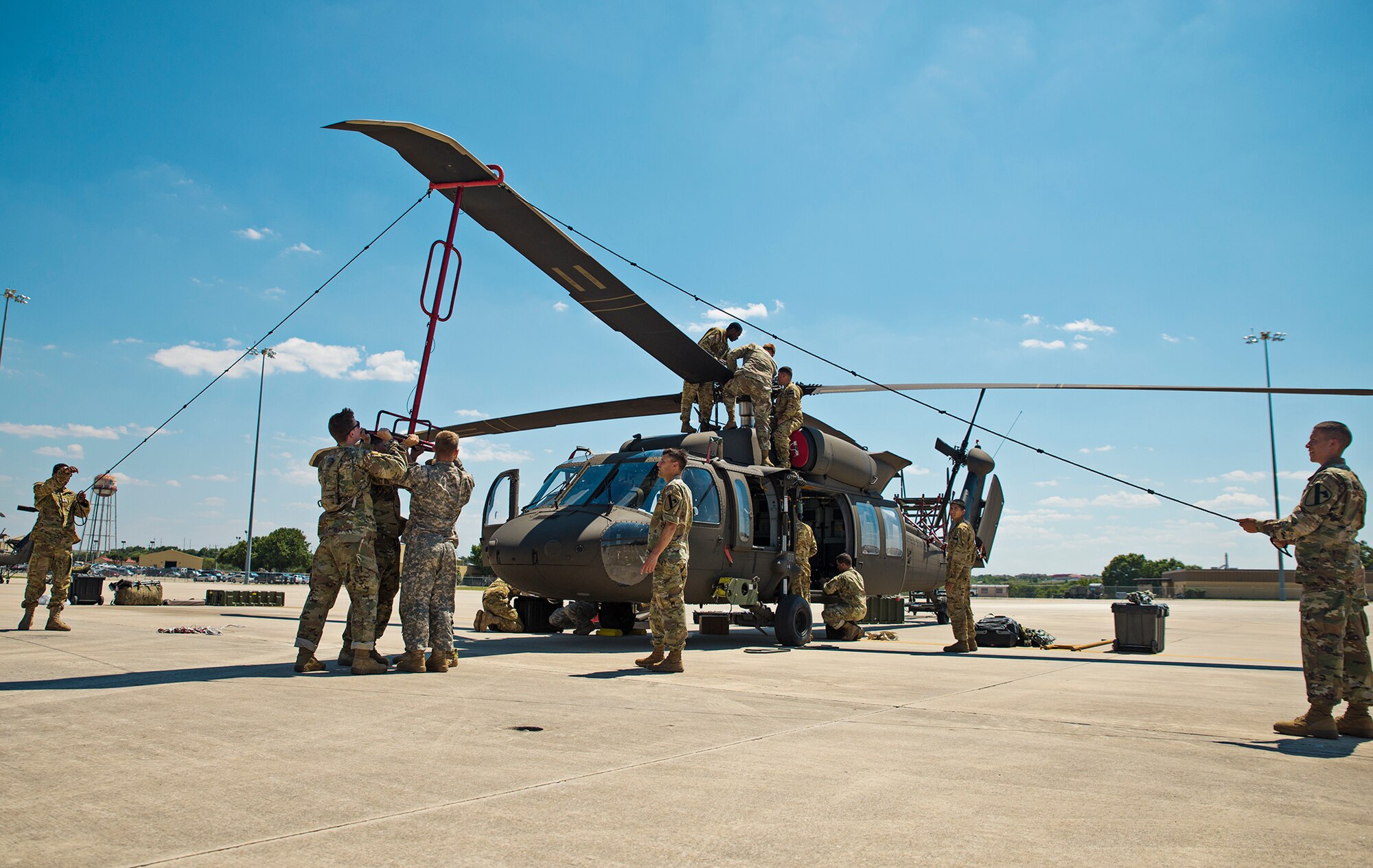 Soldiers from the 1st Calvary Division, 1st Air Combat Brigade, 615th Aviation Support Battalion from Ft. Hood, Texas remove the rotor blades from a UH-60 Black Hawk helicopter June 21, 2017 at Joint Base San Antonio-Lackland, Texas. Operation Silver Galaxy was a five-day training event that featured Airmen training Soldiers how to secure their aircraft for a deployment in the cargo area of a C-5M Super Galaxy. (U.S. Air Force photo by Benjamin Faske)