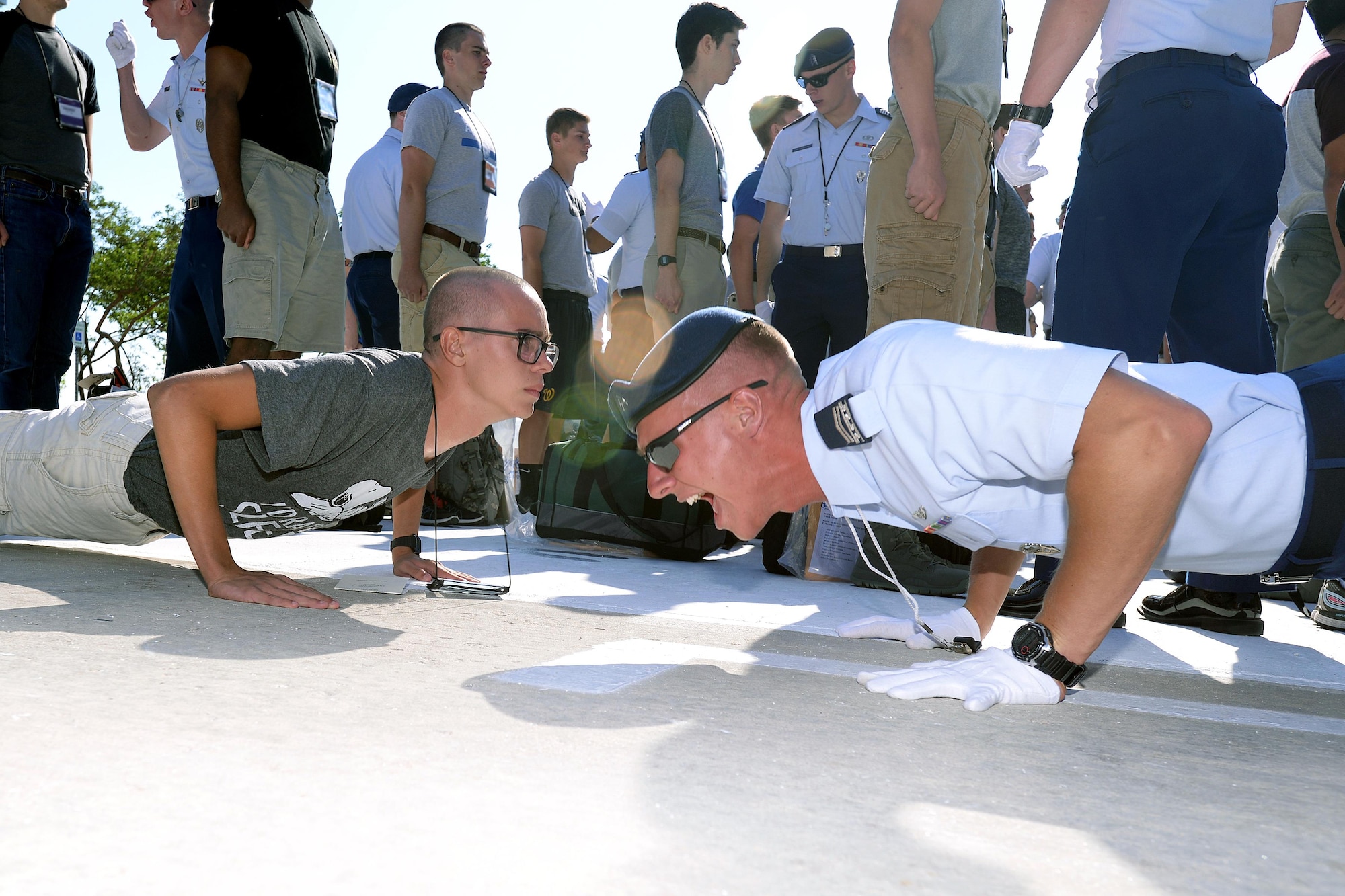 A member of the cadet training cadre at the U.S. Air Force Academy leads a basic cadet through push ups June 29, 2017. Nearly 1,200 basic cadets were scheduled to arrive at the Academy and begin Basic Cadet Training. (U.S. Air Force photo/Jason Gutierrez)