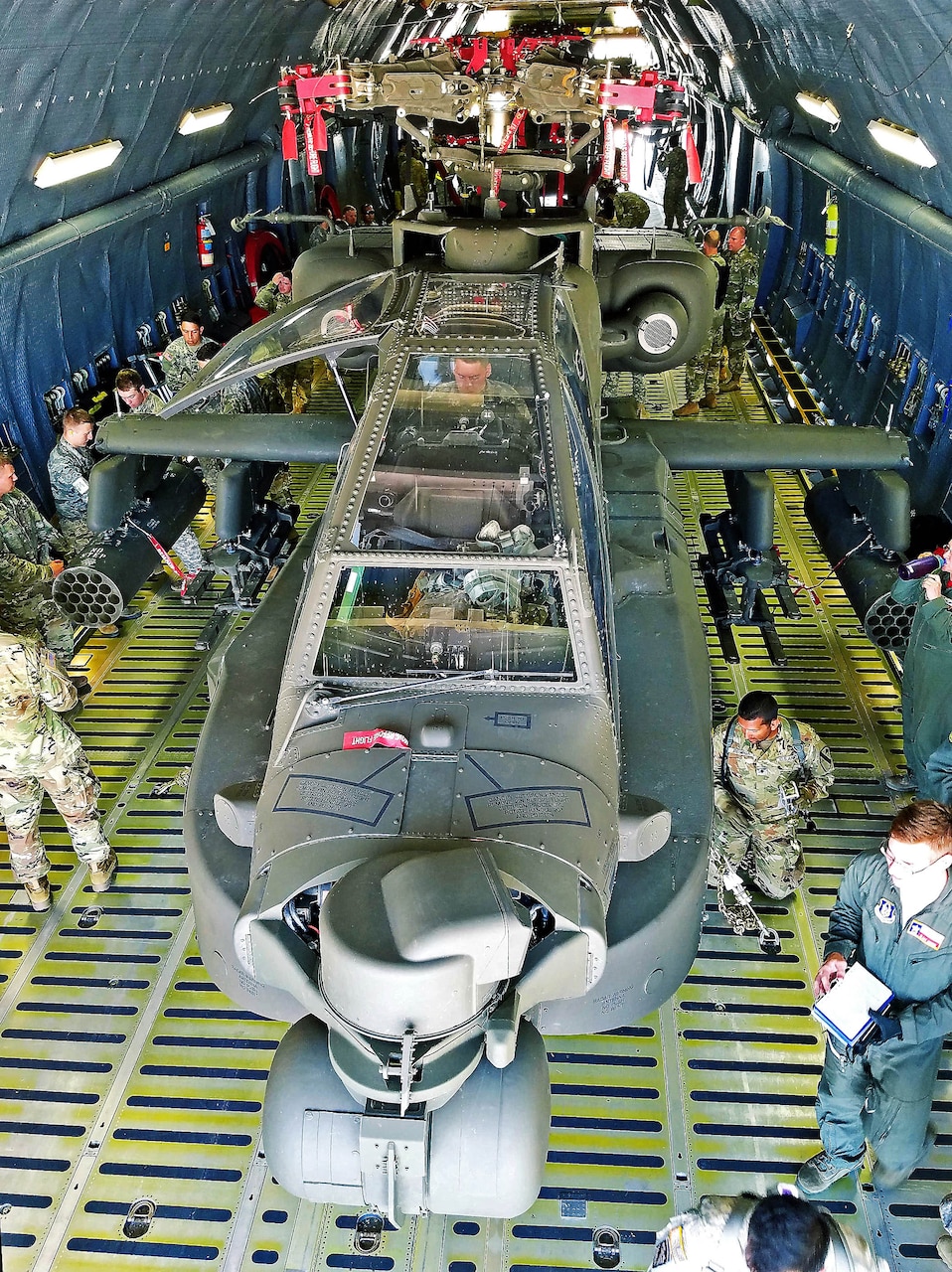 Soldiers from the 1st Calvary Division, 1st Air Combat Brigade, 615th Aviation Support Battalion from Ft. Hood, Texas and Airmen from the 433rd Airlift Wing evaluate uploaded Army helicopters June 23, 2017 at Joint Base San Antonio-Lackland, Texas. The exercise, Operation Silver Galaxy, featured Airmen training Soldiers how to secure their aircraft for a deployment in the cargo area of a C-5M Super Galaxy. (U.S. Air Force photo by Tech. Sgt. Carlos J. Trevino)