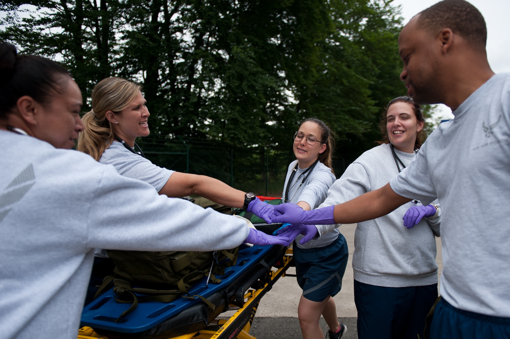 U.S. Air Force Emergency Medical Technicians join hands before a training simulation at the 86th Medical Group Simulation Center on Ramstein Air Base, Germany, June 29, 2017. As part of the EMT refresher course, the students had to work together to accomplish the training. (U.S. Air Force photo by Senior Airman Devin Boyer)