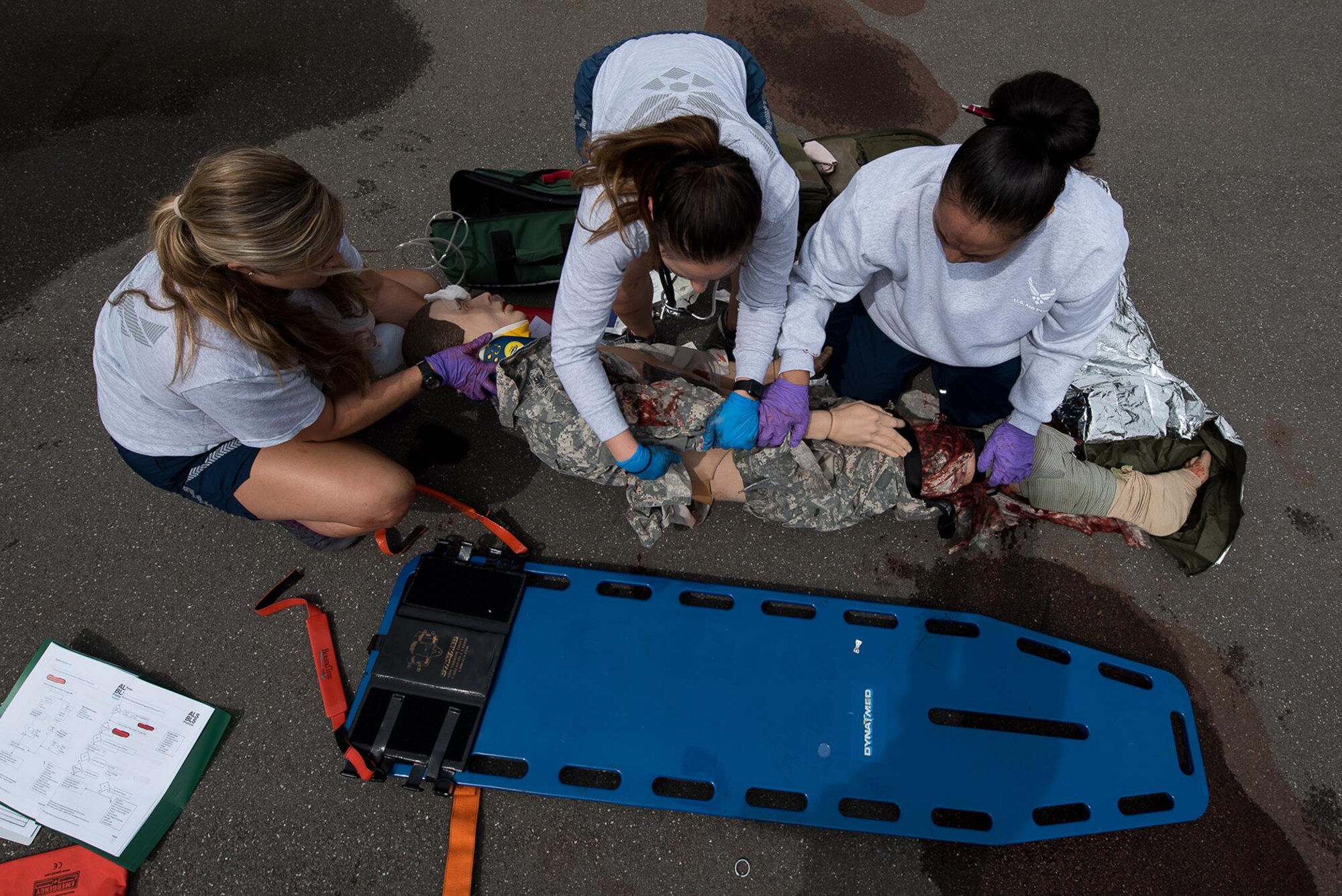 U.S. Air Force Staff Sgt. Chelsea Rittenhouse, Staff Sgt. Jozlinn Rae and Master Sgt. Joanna Siavi’i, all 86th Aeromedical Evacuation Squadron technicians, roll a mannequin onto a spine board during a training simulation at the 86th Medical Group Simulation Center on Ramstein Air Base, Germany, June 29, 2017. (U.S. Air Force photo by Senior Airman Devin Boyer)