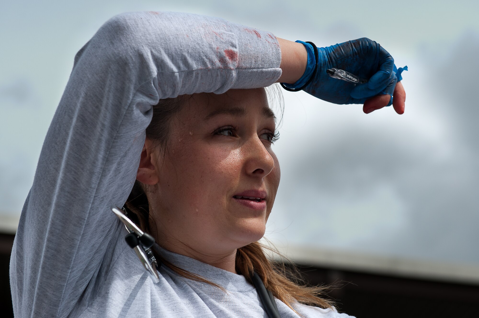 U.S. Air Force Staff Sgt. Jozlinn Rae, 86th Aeromedical Evacuation Squadron technician, wipes sweat off her forehead during a training simulation at the 86th Medical Group Simulation Center on Ramstein Air Base, Germany, June 29, 2017. The training required Rae to quickly assess her patient’s injury under pressure while constantly moving around the scene. (U.S. Air Force photo by Senior Airman Devin Boyer)