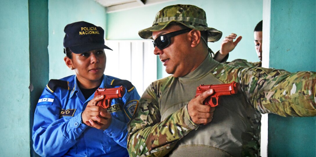 U.S. Army Staff Sgt. Marcos Dejesus, Joint Task Force-Bravo Joint Security Forces, explains tactical movements for clearing rooms to a local police officer at La Paz, Honduras, June 20, 2017.