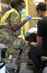 During the Innovative Readiness Training, or IRT, a Soldier and civilian dental hygienist examine a local resident in Laredo, Texas, at the Larga Vista Community Center June 27. The mission builds partnerships between US communities and the Department of Defense by addressing public health and infrastructure needs. 