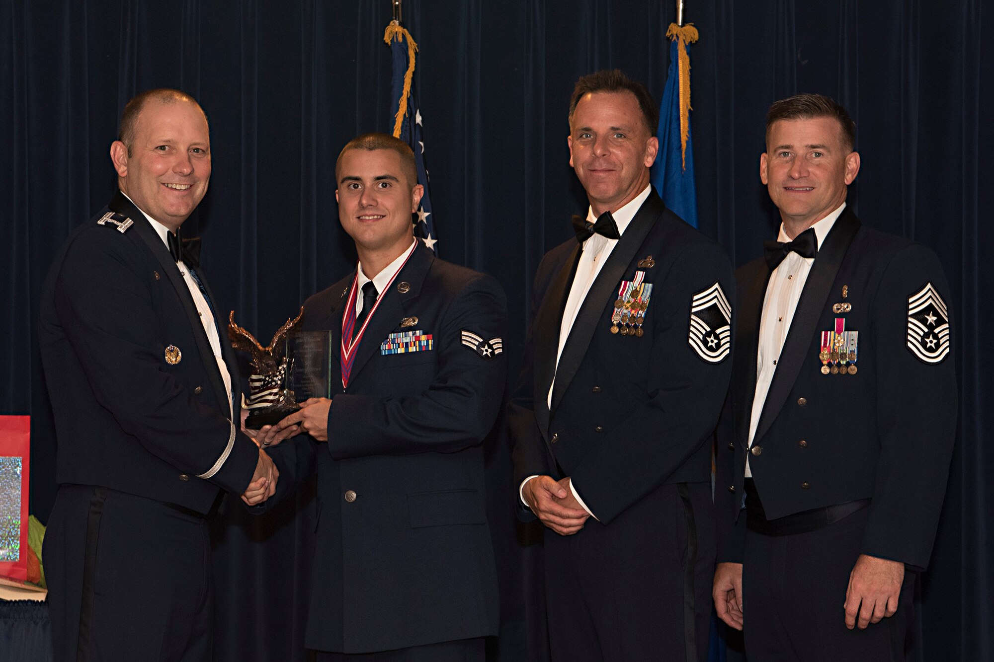 PETERSON AIR FORCE BASE, Colo. – Col. Doug Schiess, 21st Space Wing commander, presents the John L. Levitow award to Senior Airman James Brown, Air Force Space Command administrative support, during the Airmen Leadership School graduation at Peterson Air Force Base, Colo., June 22, 2017. The John L. Levitow is awarded to the most distinguished graduate from each class of the ALS and is named in honor of John L. Levitow, the lowest ranking Airman to ever receive the Medal of Honor. (U.S. Air Force photo by Steve Kotecki)