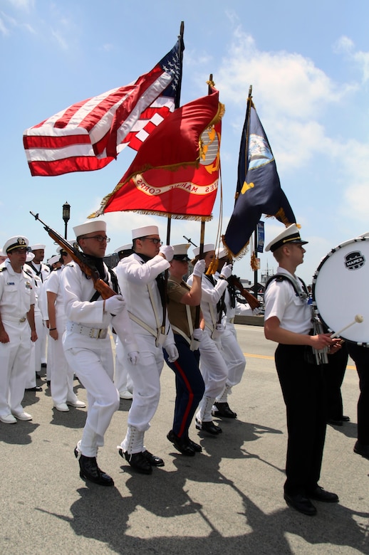 A joint color guard marches through the streets during the Sail Boston 2017 street parade held in Boston, Mass., June 19, 2017. Marines, sailors and various participants of Sail Boston paraded the streets in celebration of the occasion. Sail Boston brought together military members and sailing enthusiasts from around the world, welcoming them to sail the Boston harbor, interact with the community, and enjoy the sights of the city. (U.S. Marine Corps photo by Cpl. Mackenzie Gibson/Released)