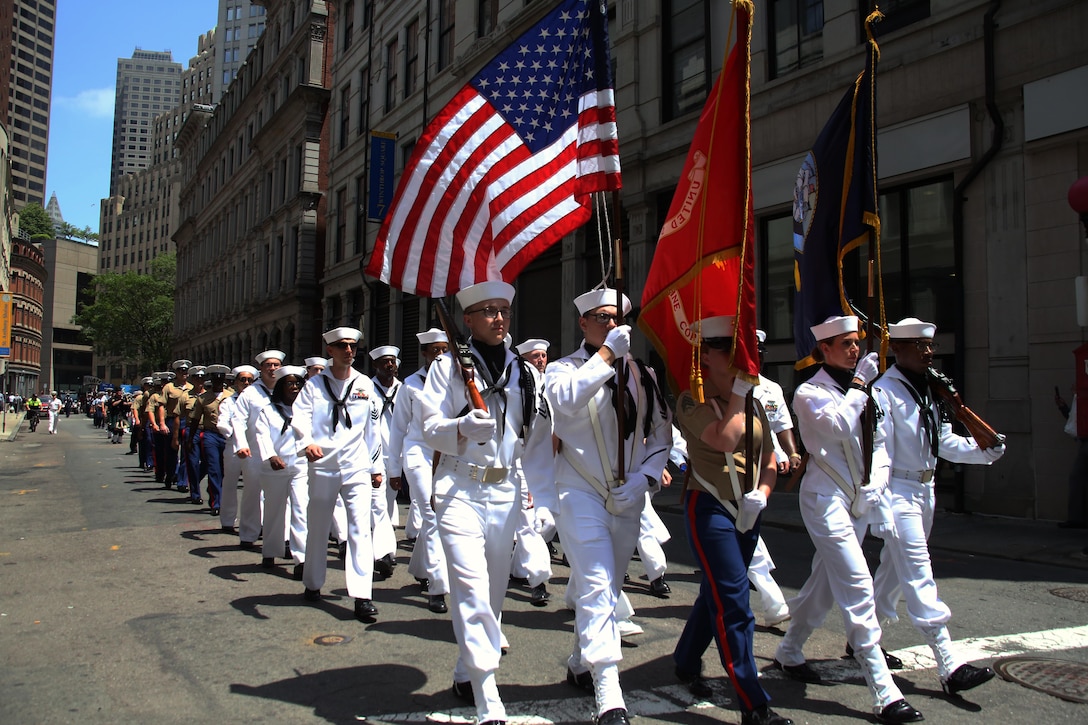Marines and Sailors march through the streets during the Sail Boston 2017 street parade held in Boston, Mass., June 19, 2017. Marines, Sailors and various participants of Sail Boston paraded the streets in celebration of the occasion. Sail Boston brought together military members and sailing enthusiasts from around the world, welcoming them to sail the Boston harbor, interact with the community, and enjoy the sights of the city. (U.S. Marine Corps photo by Cpl. Mackenzie Gibson/Released)
