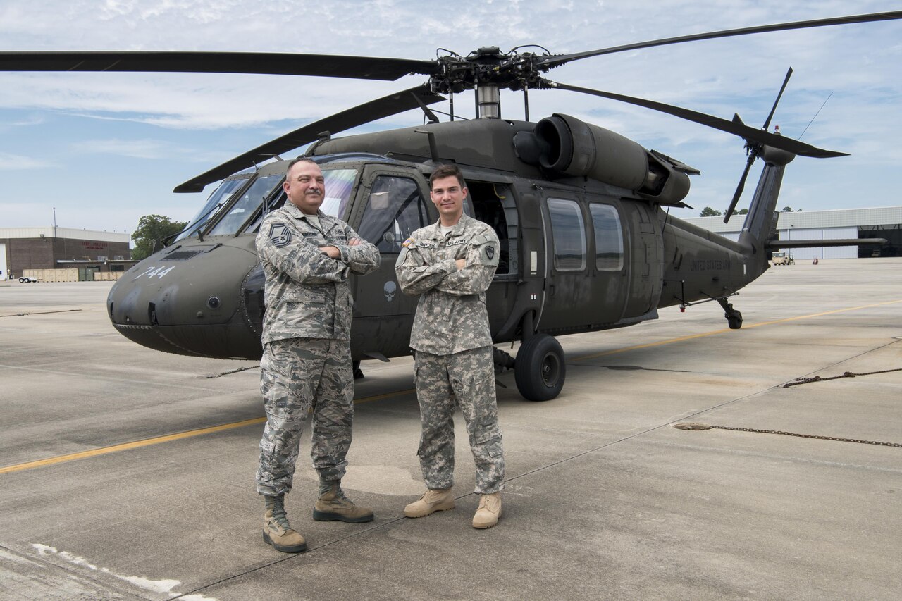 Air Force Senior Master Sgt. Edward Snyder, with the South Carolina Air National Guard’s 169th Fighter Wing, stands with his son, 2nd Lt. Michael Snyder, assigned to the Carolina Army National Guard’s Alpha Company, 1st Battalion, 111th Aviation Regiment, near a UH-60 Black Hawk helicopter at McEntire Joint National Guard Base in Eastover, S.C., June 13, 2017. The senior Snyder's example of service to others inspired his son to join the National Guard and become a Black Hawk pilot. South Carolina Army National Guard photo by Spc. Chelsea Baker