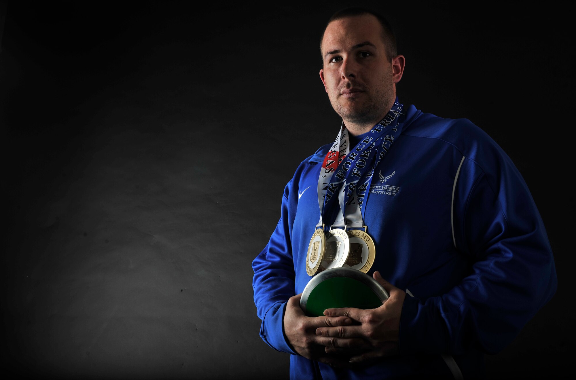 Retired U.S. Air Force Staff Sgt. Clifton Flint, formerly 48th Security Forces Squadron base defense operations center controller, poses for a photo June 30, 2017, on RAF Mildenhall, England, with his discus and the bronze, silver and gold medals he earned at the Wounded Warrior Air Force Games held at Nellis Air Force Base, Nevada, earlier this year. Flint suffers from post-traumatic stress disorder, brought on after sustaining a traumatic brain injury while deployed to Iraq in 2005. (U.S. Air Force photo by Staff Sgt. Micaiah Anthony)