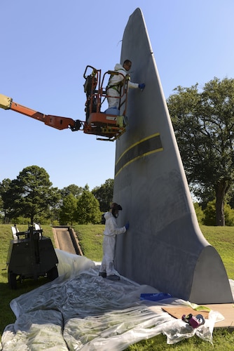 Airman 1st Class Steven Stoy and Senior Airman Wesley Garnes, 19th Maintenance Squadron aircraft structural maintaince, wipe sanding dust off of a C-130J tail static display June 27, 2017, at Little Rock Air Force Base, Ark. The tail restoration helps prevent corrosion. Steps completed with a hose or spray gun have to be done by hand outside due to environmental concerns. (U.S. Air Force photo by Airman Rhett Isbell)