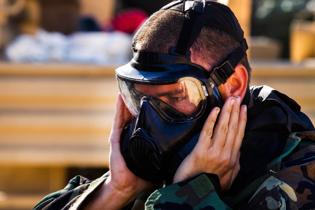 Army Sgt. John Garthwait clears his gas mask before participating in a decontamination mission during Warrior Exercise at Fort Hunter Liggett, Calif., June 21, 2017. Garthwait is assigned to the Army Reserve's 340th Chemical Company.  Army photo by Spc. Derek Cummings