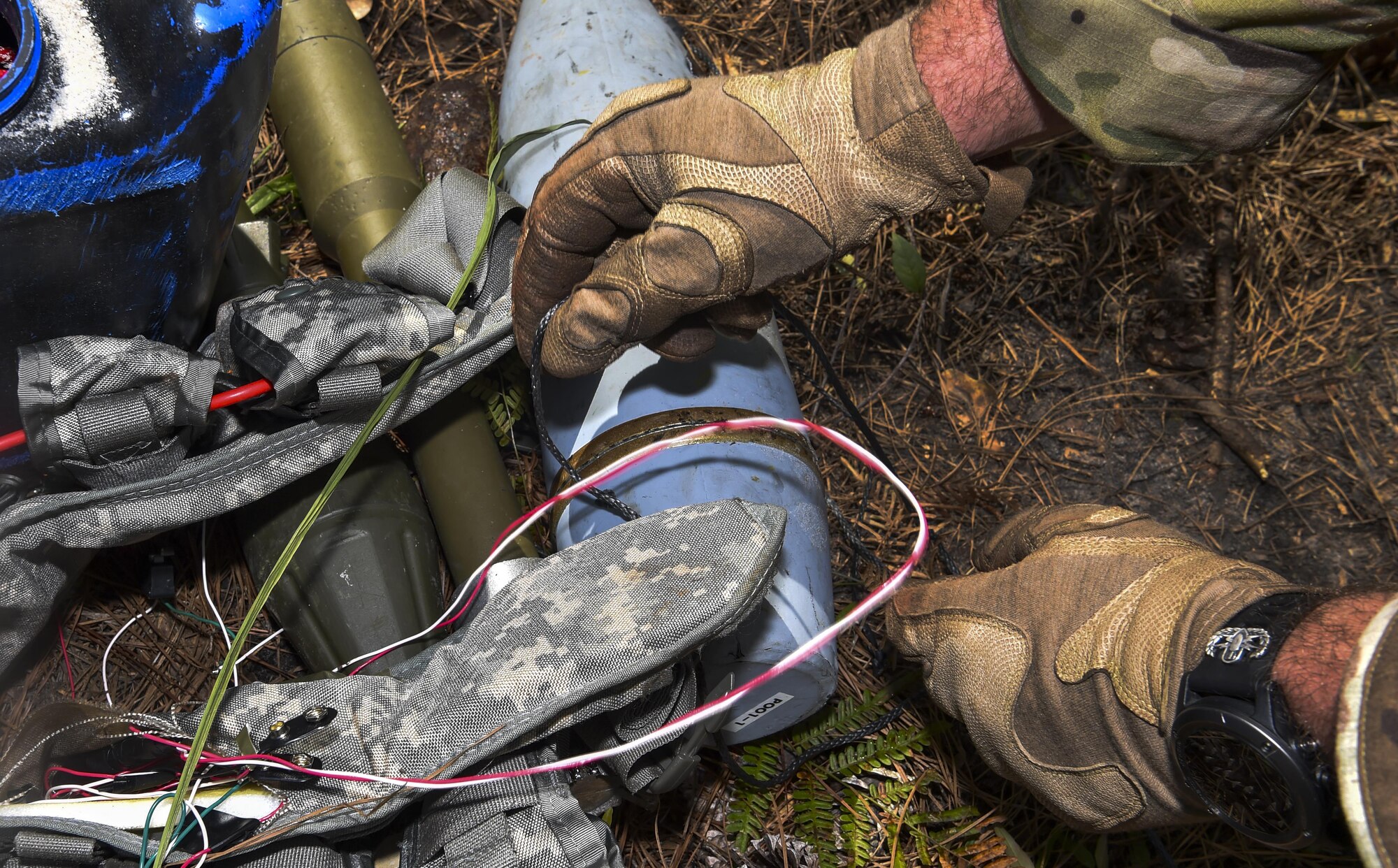 Senior Airman Dylan Babb, 628th Civil Engineer Squadron explosive ordnance technician, investigates a weapons cache during training operation Mogul Wrath, June 27, 2017. EOD here trained over the course of a week to ensure they are retaining knowledge and can efficiently use their skillsets in real world situations. 
