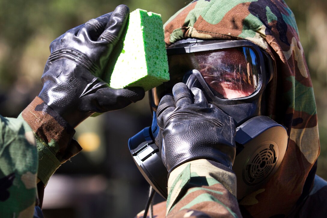 Army reservist Spc. Isac Rodriguez, not shown, washes Spc. Kamel Ayouni's gas mask during a decontamination mission that's part of Warrior Exercise at Fort Hunter Liggett, Calif., June 21, 2017. Army photo by Spc. Derek Cummings