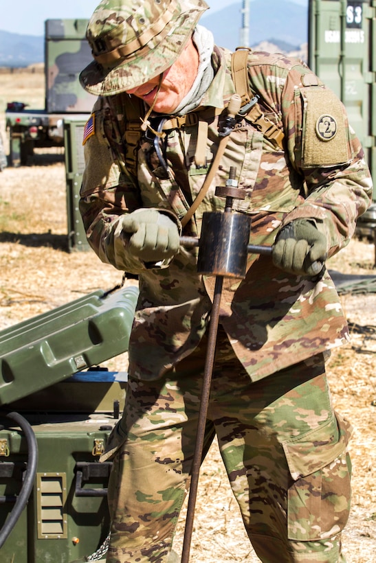 Army Capt. Fikao Schoeneweiss removes a grounding pole to prevent data exfiltration during Warrior Exercise at Fort Hunter Liggett, Calif., June 22, 2017. Schoeneweiss is assigned to the Army Reserve's 352nd Combat Support Hospital, 2nd Medical Brigade. Army photo by Spc. Derek Cummings