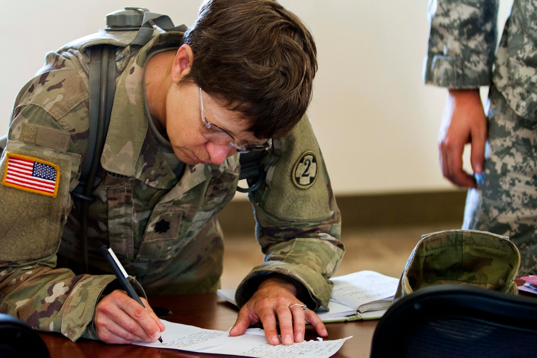 Army Lt. Col. Lisa Spahr takes notes during an after action review part of Warrior Exercise at Fort Hunter Liggett, Calif., June 22, 2017. Spahr is assigned to the Army Reserve's 1972nd Combat Operational Stress Control Company. Army photo by Spc. Derek Cummings