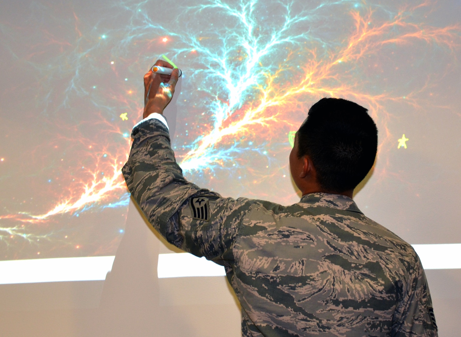 Senior Airman Travis Napaepae, Medical Education and Training Campus Information Management Division call center manager, tries his hand drawing on an interactive SMART screen displaying the circulatory system.