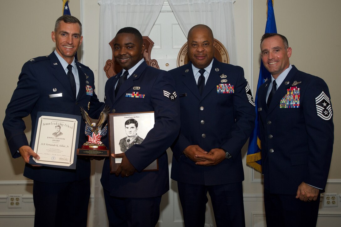 U.S. Air Force Senior Airman Fernando Elliott, 31st Intelligence Squadron, receives the John L. Levitow Award from Col. Daniel Lasica, 20th Fighter Wing commander, for class 17-5 of the Senior Master Sgt. David B. Reid Airman Leadership School at Shaw Air Force Base, S.C., June 30, 2017. The Levitow Award is given to the graduate with the highest average of instructor and student points, and is the highest award in enlisted professional military education. (U.S. Air Force photo by Senior Airman Michael Cossaboom)