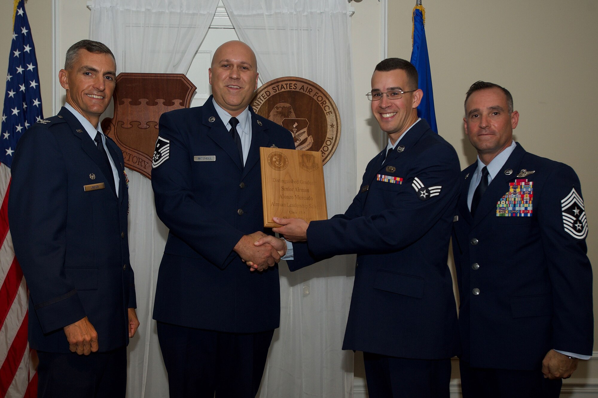 U.S. Air Force Senior Airman Alonzo Mercado, 3rd Intelligence Squadron, receives a Distinguished Gradate Award during the Senior Master Sgt. David B. Reid Airman Leadership School Class 17-5 graduation ceremony at Shaw Air Force Base, S.C., June 30, 2017. Distinguished graduate awards are given to the top 10 percent of the class for total point accumulation. (U.S. Air Force photo by Senior Airman Michael Cossaboom)