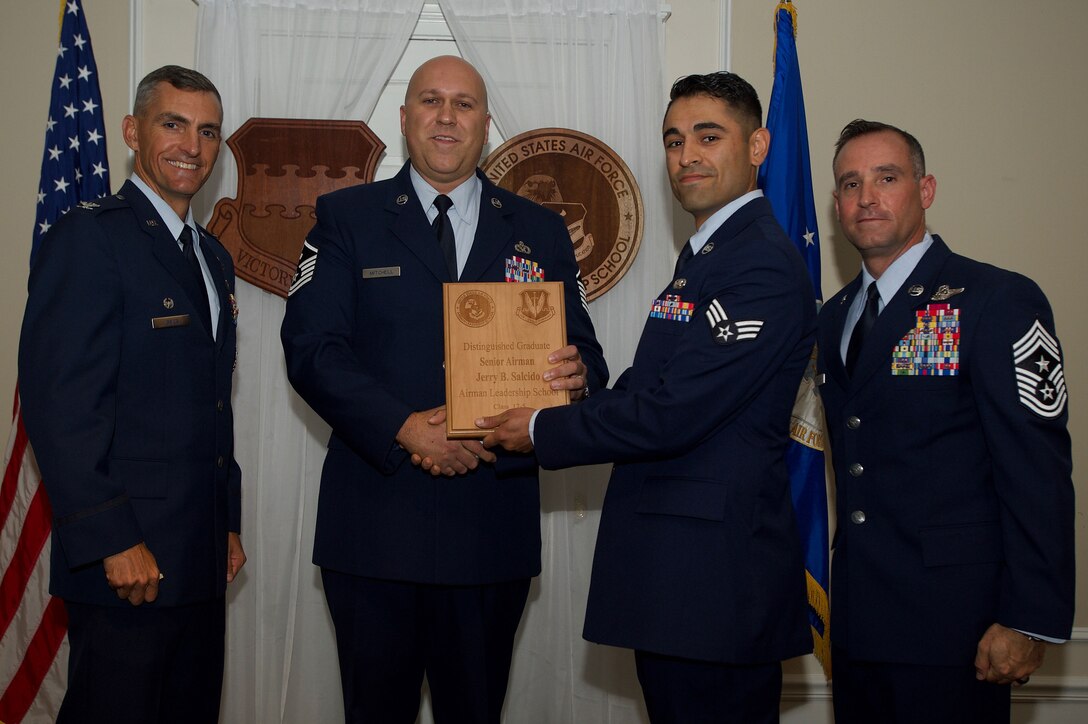 U.S. Air Force Senior Airman Jerry Salcido, 20th Operations Support Squadron, receives a Distinguished Gradate Award during the Senior Master Sgt. David B. Reid Airman Leadership School Class 17-5 graduation ceremony at Shaw Air Force Base, S.C., June 30, 2017. Distinguished graduate awards are given to the top 10 percent of the class for total point accumulation. (U.S. Air Force photo by Senior Airman Michael Cossaboom)