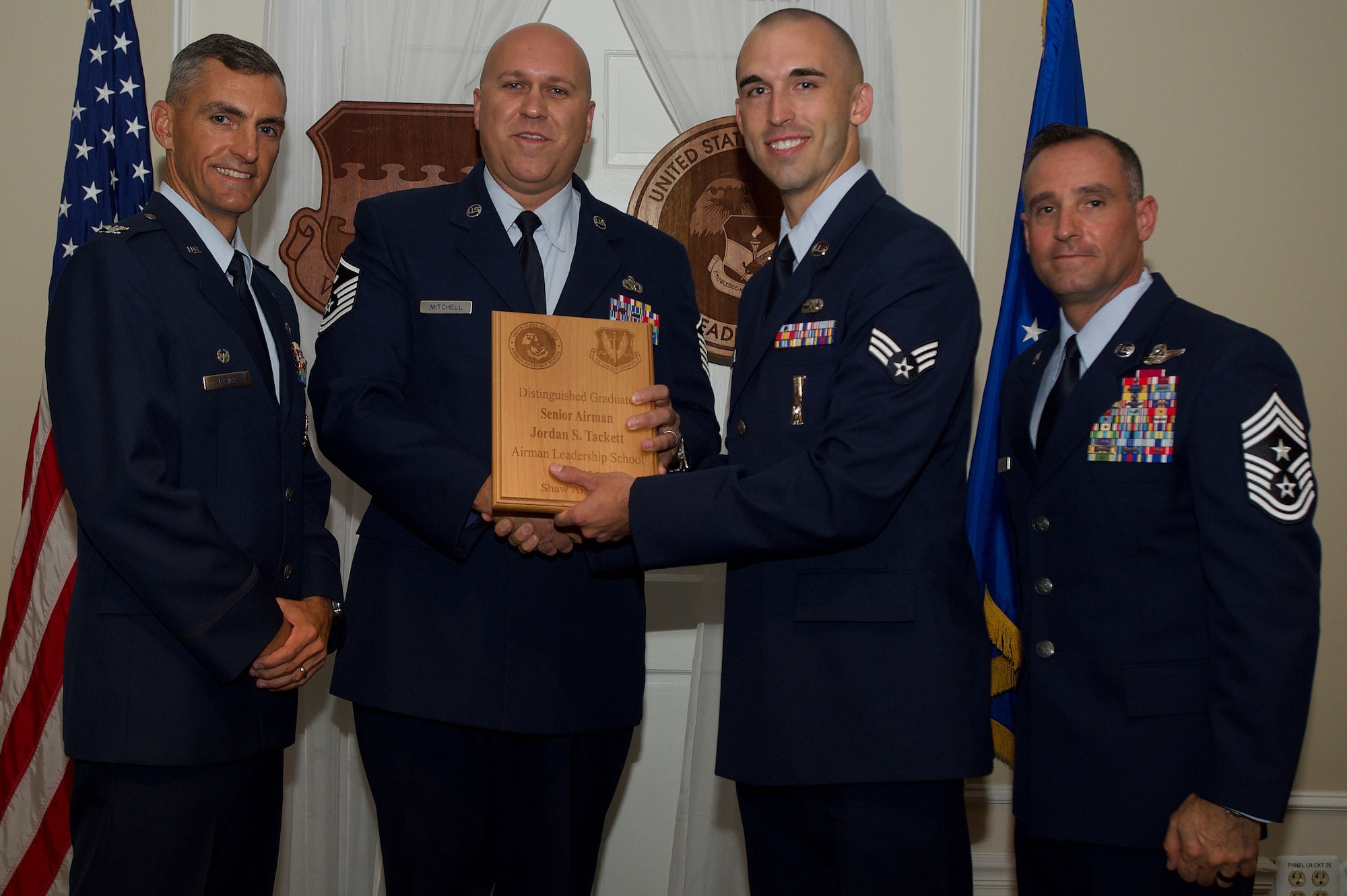 U.S. Air Force Senior Airman Jordan Tackett, 20th Aircraft Maintenance Squadron, receives a Distinguished Gradate Award during the Senior Master Sgt. David B. Reid Airman Leadership School Class 17-5 graduation ceremony at Shaw Air Force Base, S.C., June 30, 2017. Distinguished graduate awards are given to the top 10 percent of the class for total point accumulation. (U.S. Air Force photo by Senior Airman Michael Cossaboom)