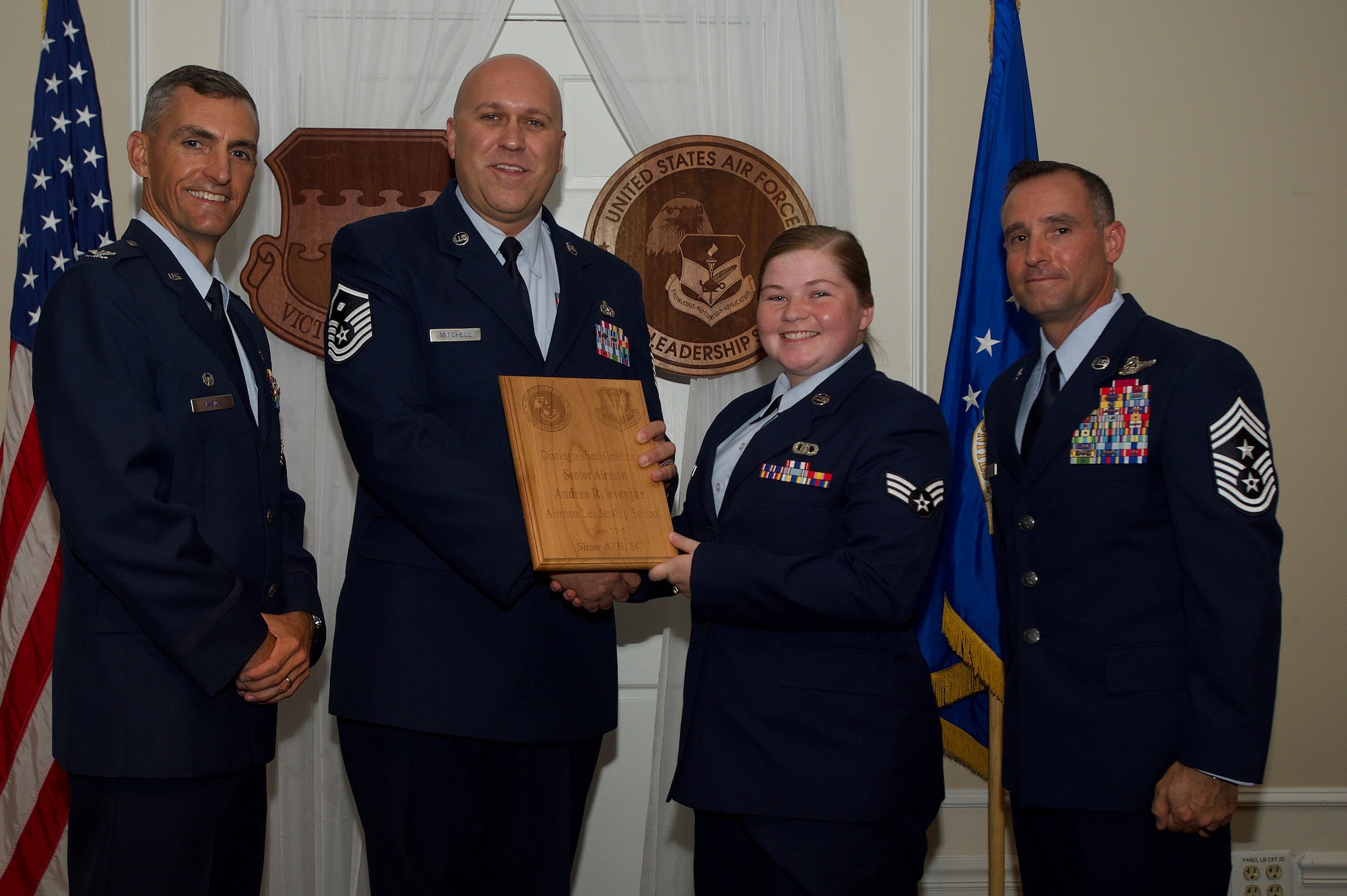 U.S. Air Force Senior Airman Andrea Levesque, 28th Operational Weather Squadron, receives a Distinguished Gradate Award during the Senior Master Sgt. David B. Reid Airman Leadership School Class 17-5 graduation ceremony at Shaw Air Force Base, S.C., June 30, 2017. Distinguished graduate awards are given to the top 10 percent of the class for total point accumulation. (U.S. Air Force photo by Senior Airman Michael Cossaboom)