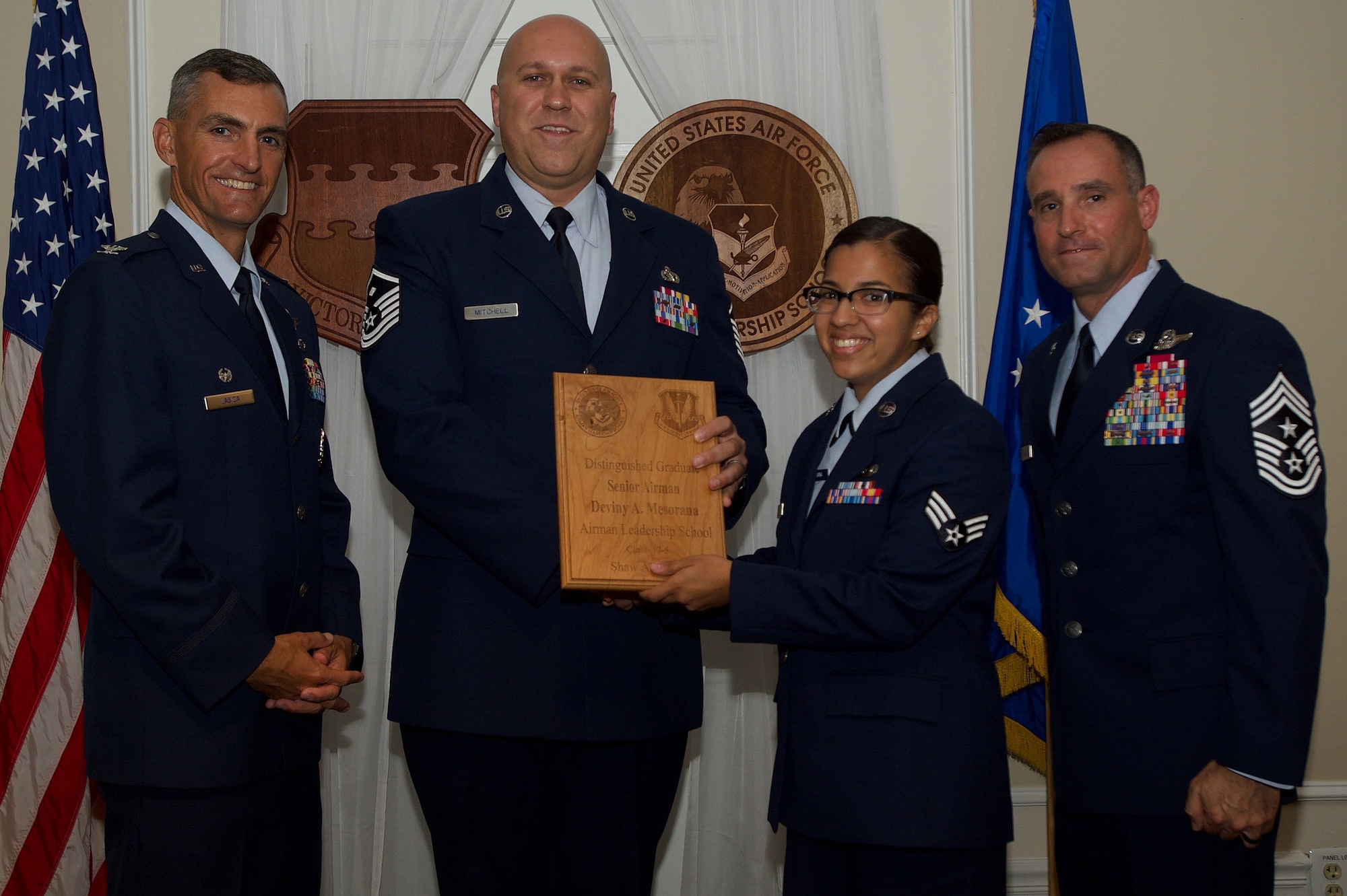 U.S. Air Force Senior Airman Deviny Mesorana, 31st Intelligence Squadron, receives a Distinguished Gradate Award during the Senior Master Sgt. David B. Reid Airman Leadership School Class 17-5 graduation ceremony at Shaw Air Force Base, S.C., June 30, 2017. Distinguished graduate awards are given to the top 10 percent of the class for total point accumulation. (U.S. Air Force photo by Senior Airman Michael Cossaboom)