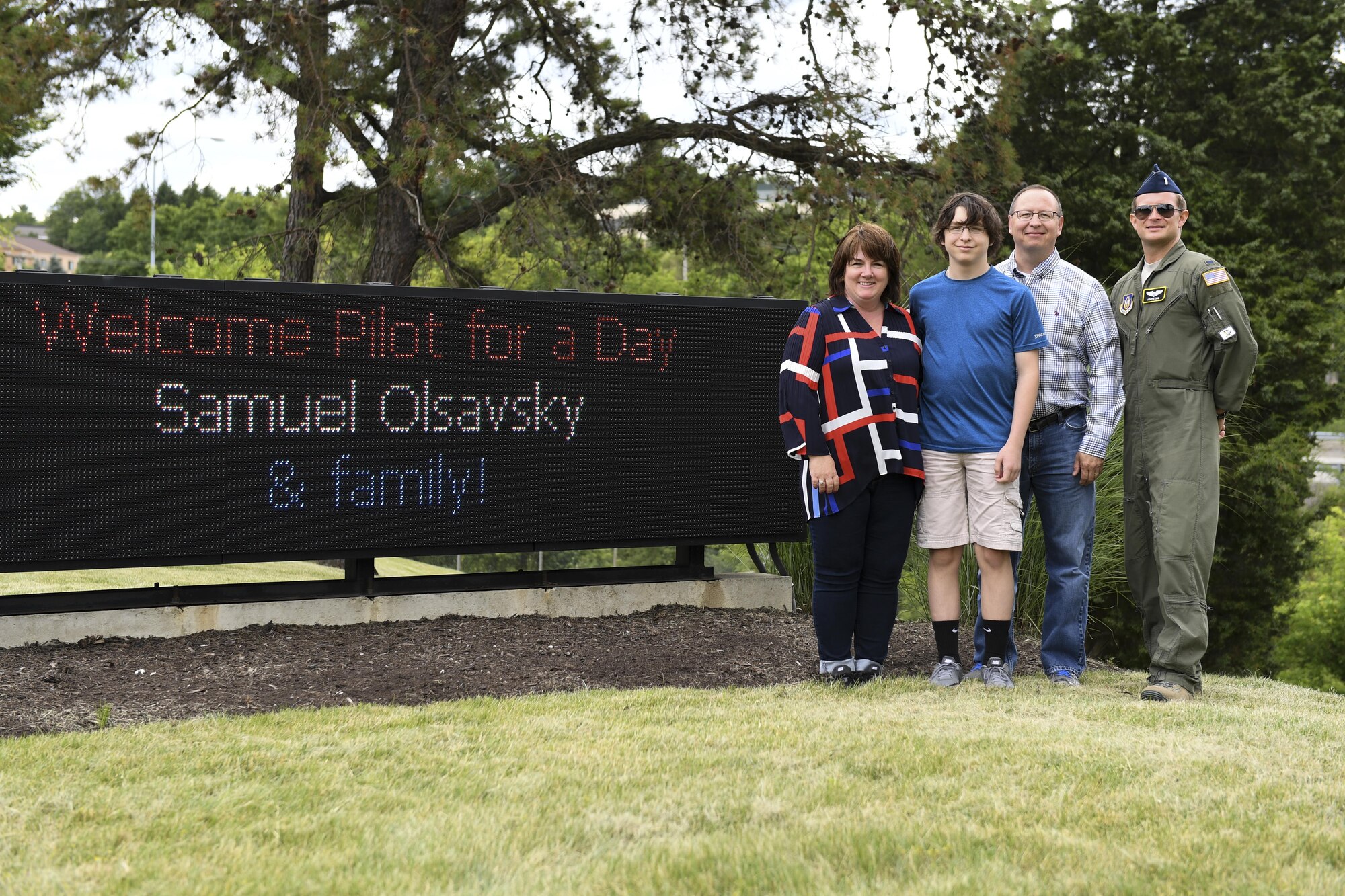 Samuel Olsavsky, pilot for a day with the Pittsburgh International Airport Air Reserve Station, his family and 2nd Lt. Adam Stahl, pilot with the 758th Airlift Squadron, stand beside a marquee welcoming him on base June 27, 2017. Olsavsky was visiting the base to participate in the Pilot for a Day program, which gives local youth undergoing treatment a chance to learn about what Pittsburgh Airmen do every day. (U.S. Air Force photo by Senior Airman Beth Kobily)