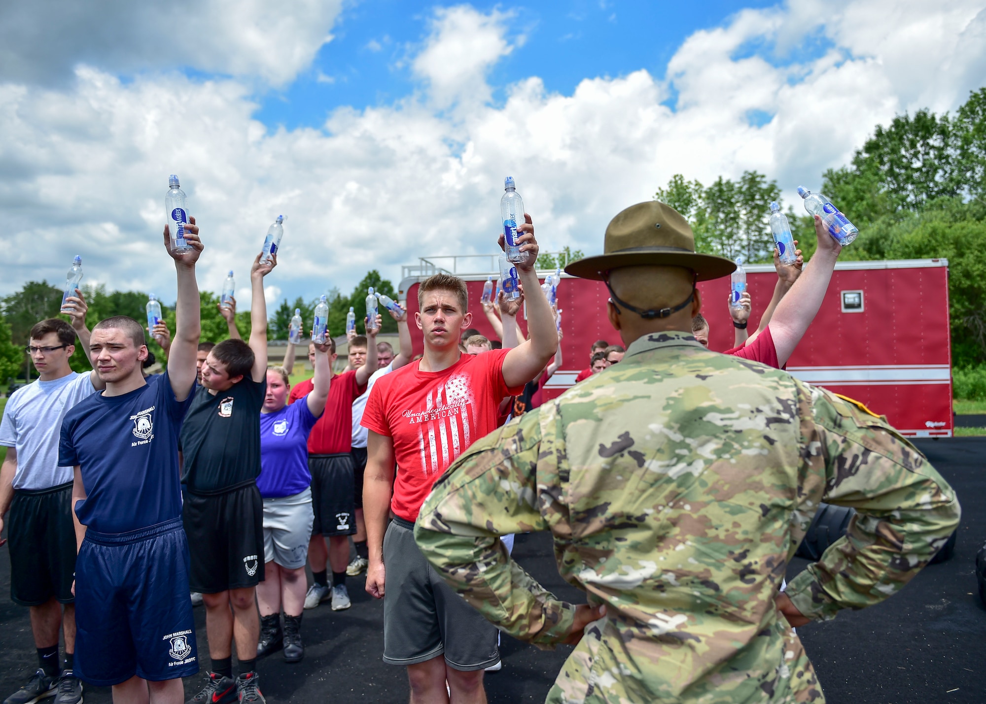 U.S. Army Staff Sgt. Brandon Curry, a drill sergeant with the 1st Bn., 390th Inf. Reg., inspects Junior Reserve Officer Training Corps (JROTC) cadets’ water bottles to ensure they’re hydrating properly during physical training, June 21, 2017. The cadets were here for an encampment facilitated by 910th Airlift Wing Airmen and Curry that provided a five-day experience teaching military skills and replicating aspects of Basic Military Training. JROTC is a program sponsored by the Armed Forces for high school students across the country. (U.S. Air Force photo/Eric White)