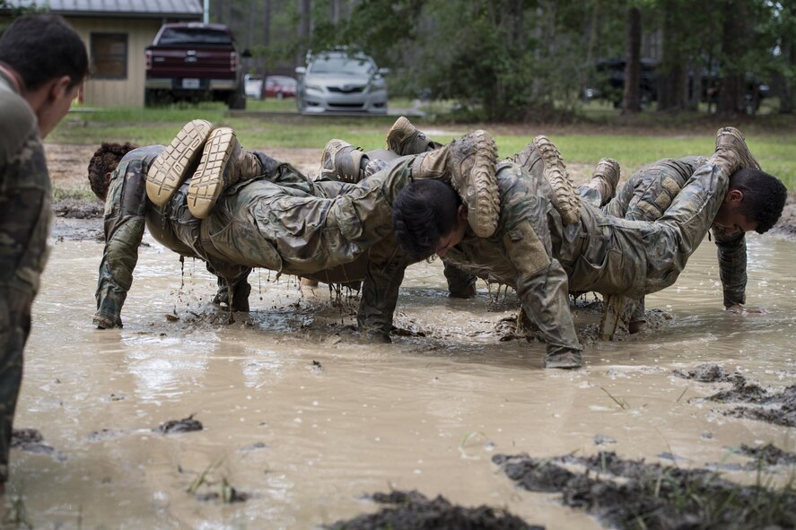 Airmen from the 822d Base Defense Squadron execute team push-ups during the Scorpion Fire Team Challenge, June 28, 2017, at Moody Air Force Base, Ga. The challenge was designed to push the Airmen to their physical and mental limits, by incorporating written tests, hostage rescues, blindfolded weapons assembly and physical exertion sessions among 14 other challenges. Eighteen four-person teams competed during the two-day event for various prizes and bragging rights. (U.S. Air Force photo by Senior Airman Janiqua P. Robinson)