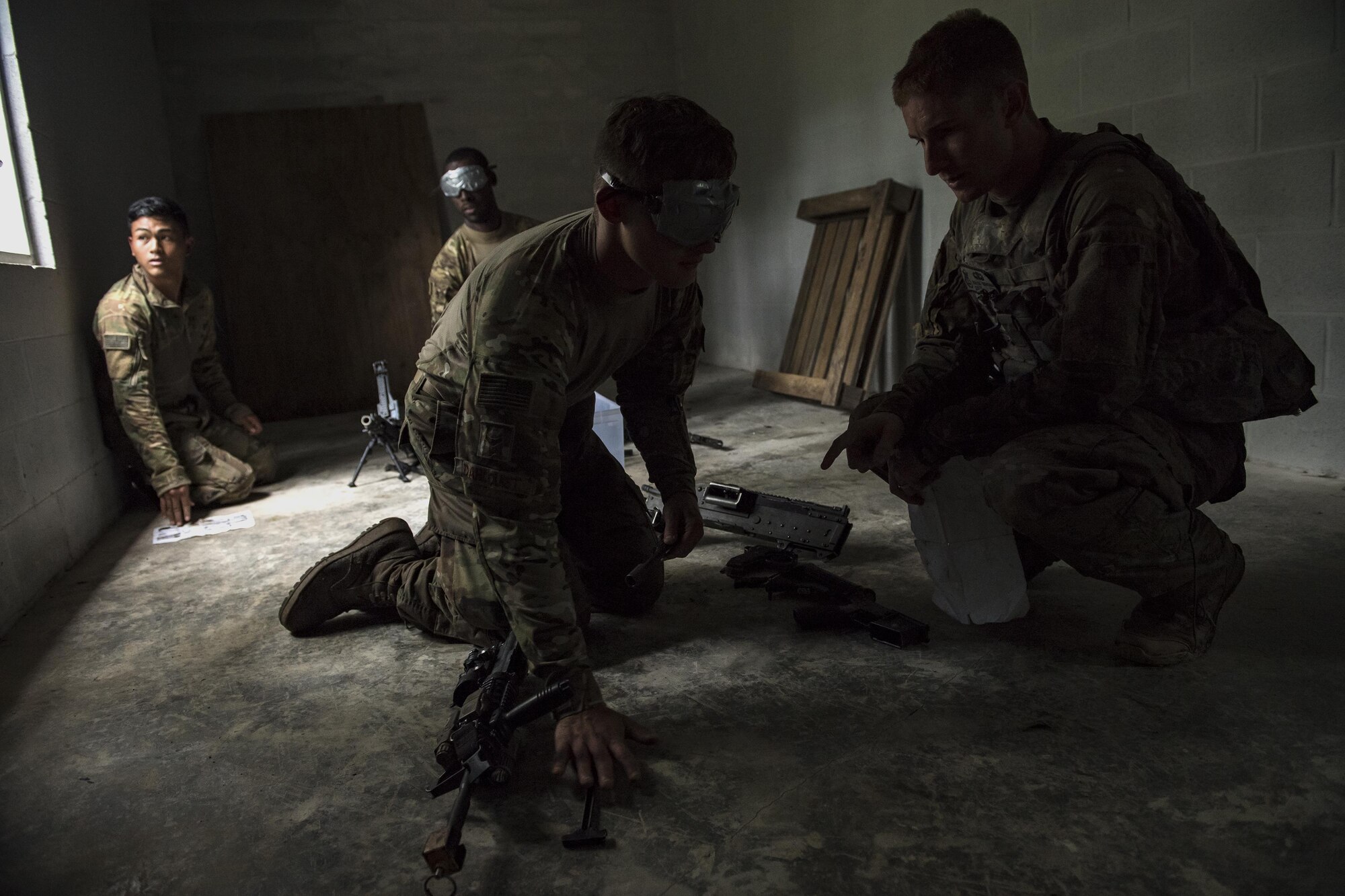 Airmen from the 822d Base Defense Squadron direct blindfolded Airmen assembling weapons during the Scorpion Fire Team Challenge, June 28, 2017, at Moody Air Force Base, Ga. The challenge was designed to push the Airmen to their physical and mental limits, by incorporating written tests, hostage rescues, blindfolded weapons assembly and physical exertion sessions among 14 other challenges. Eighteen four-person teams competed during the two-day event for various prizes and bragging rights. (U.S. Air Force photo by Senior Airman Janiqua P. Robinson)