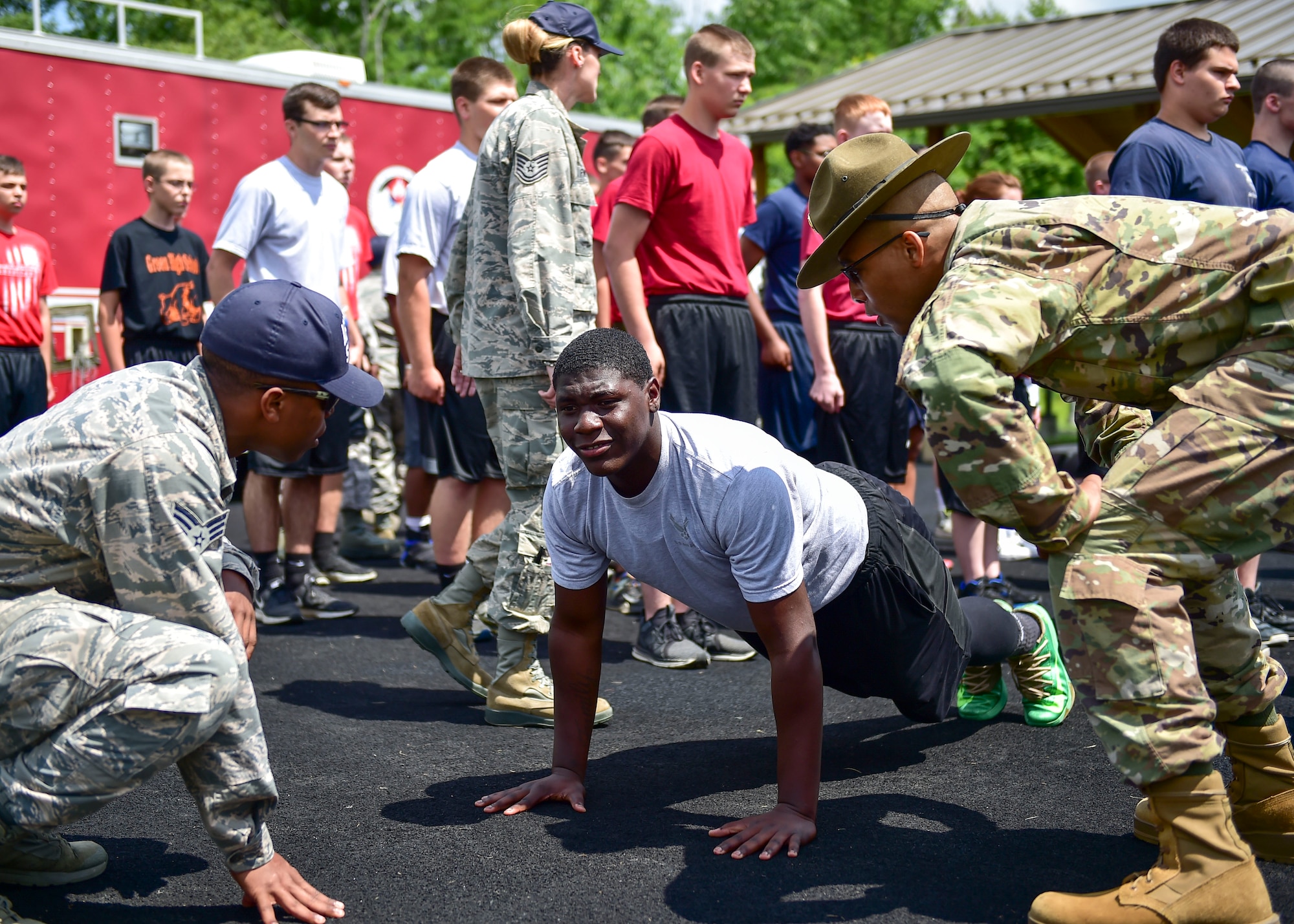 U.S. Air Force Reserve Senior Airman James Smith III, a member of the 910th Force Support Squadron, and U.S. Army Staff Sgt. Brandon Curry, a drill sergeant with the 1st Bn., 390th Inf. Reg., motivate a Reserve Officer Training Corps (JROTC) cadet doing pushups during an encampment here, June 21, 2017. The encampment, facilitated by 910th Airlift Wing Airmen, provided a five-day experience teaching military skills and replicating aspects of Basic Military Training. JROTC is a program sponsored by the Armed Forces for high school students across the country. (U.S. Air Force photo/Eric White)