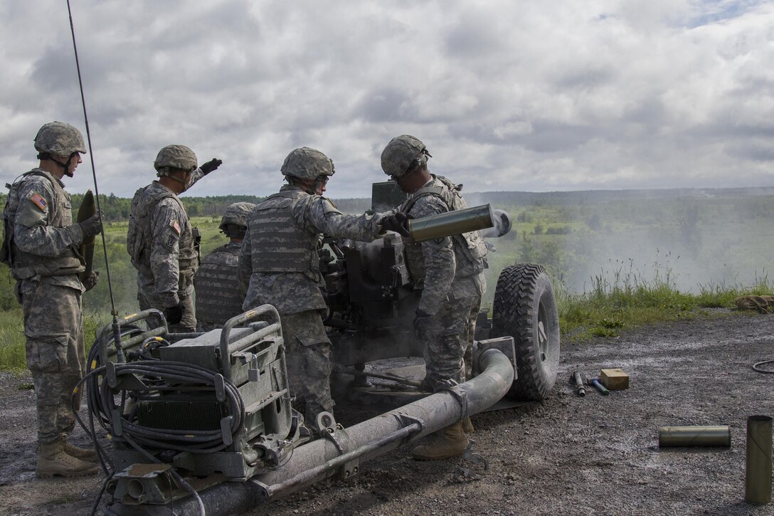 A Massachusetts Army National Guard member tosses an empty casing after a firing mission during an M119A3 105 mm howitzer live-fire exercise at Fort Drum, N.Y., June 20, 2017. Army National Guard photo by Spc. Avery Cunningham