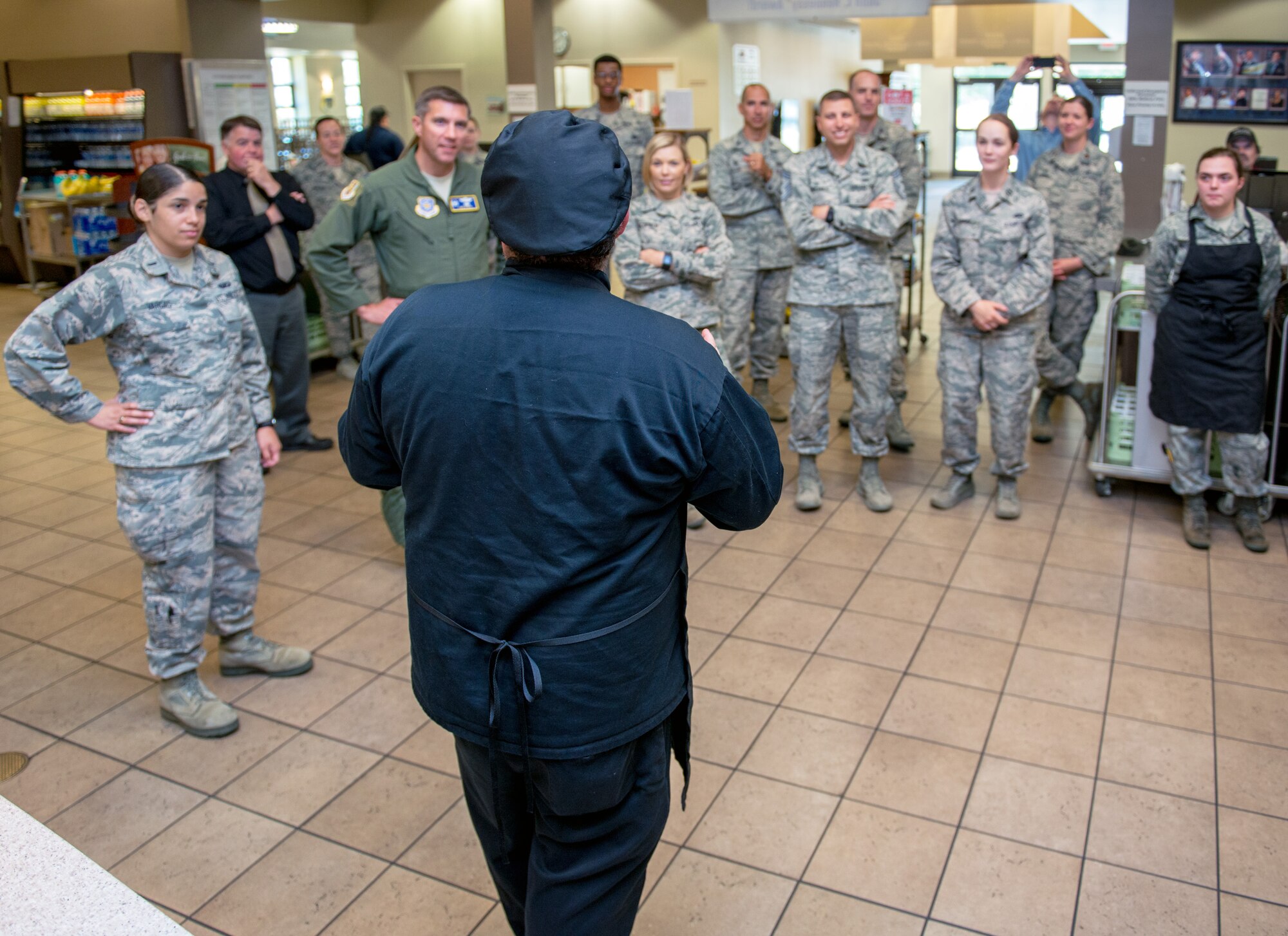 Maynard Oestreich, executive chef for Aramark explains his dish to the 60th Air Mobility Wing commanders and chiefs during the BIBIM Box tasting featuring Korean food at Sierra Inn Dining Facility, Travis Air Force Base, Calif., June 29, 2017. Oestreich a former U.S. Navy veteran and an award-winning chef from Napa Valley, Calif., took the head chef position so he could mentor young Airmen. (U.S. Air Force photo by Louis Briscese)