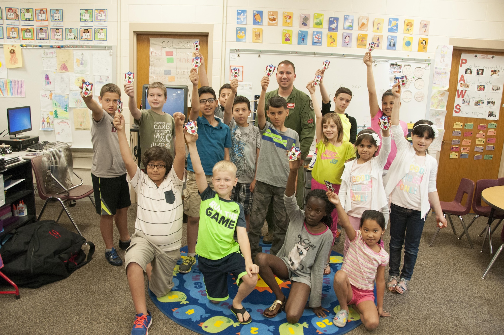 Col. Tom Bladen, 104th Fighter Wing operations group commander, visits refugee students at Highland Elementary School in Westfield, Massachusetts, June 26, 2017. The students received a 104th Fighter Wing patch and raised the patch up high while taking a photo with Col. Bladen after hearing about the 104th Fighter Wing mission to protect and serve. The visit served as a means to help the children understand why they hear the loud screeching F15 jets flying overhead when playing outside and to help them understand the 104th Fighter Wing flies to protect. Bladen speaks to the students about the F-15 Eagle and explains to the refugee students on how the pilots practice a lot just as soccer players practice. (U.S. Air National Guard photo by Senior Master Sgt. Julie Avey)