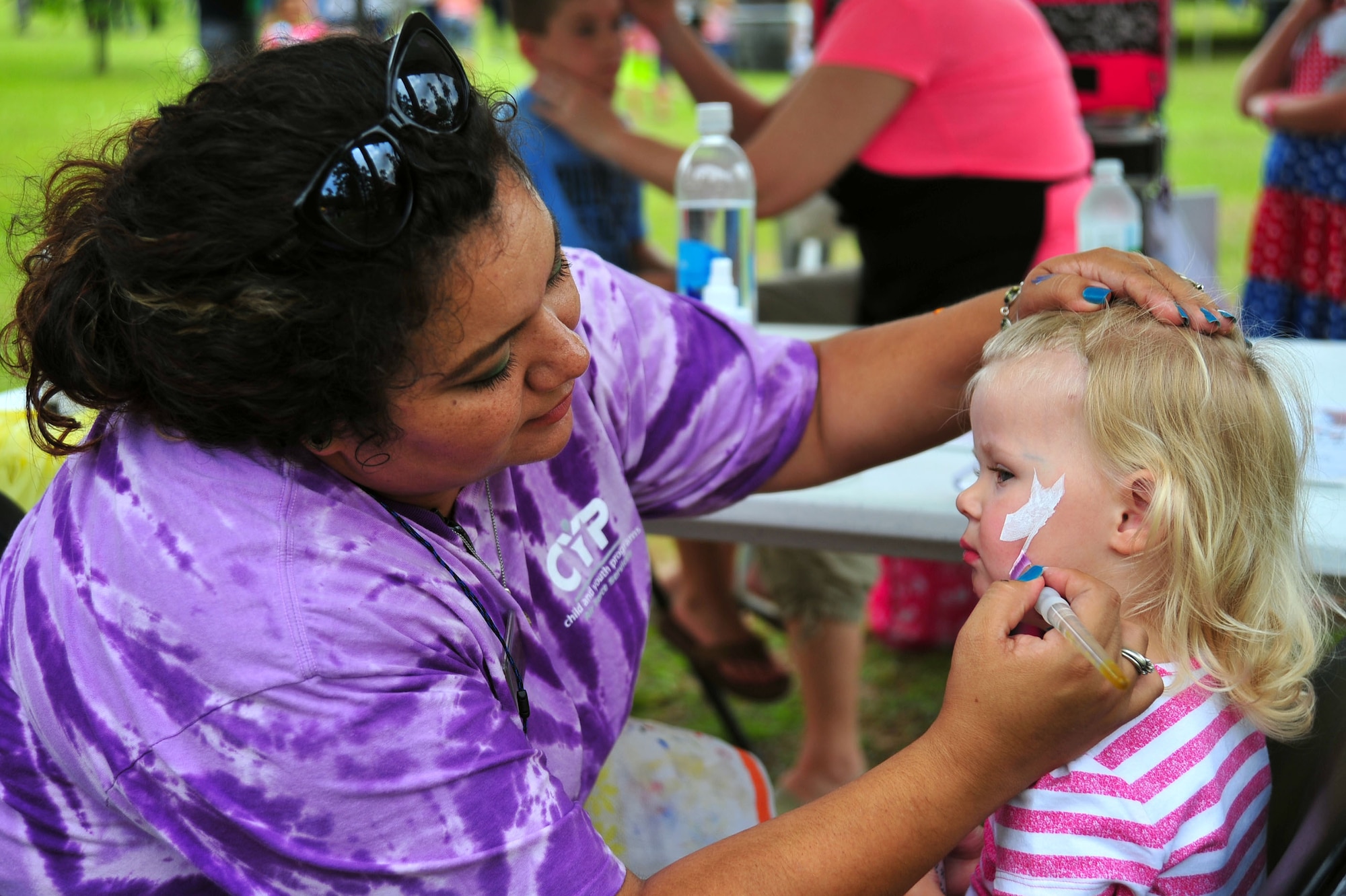 Celeste Montez, 20th Force Support Squadron child and youth program assistant, paints a child’s face during the Freedom Bash at Shaw Air Force Base, S.C., June 30, 2017. The annual bash included family-friendly activities such as face-painting, cornhole and inflatable castles. (U.S. Air Force photo by Airman 1st Class Kathryn R.C. Reaves)