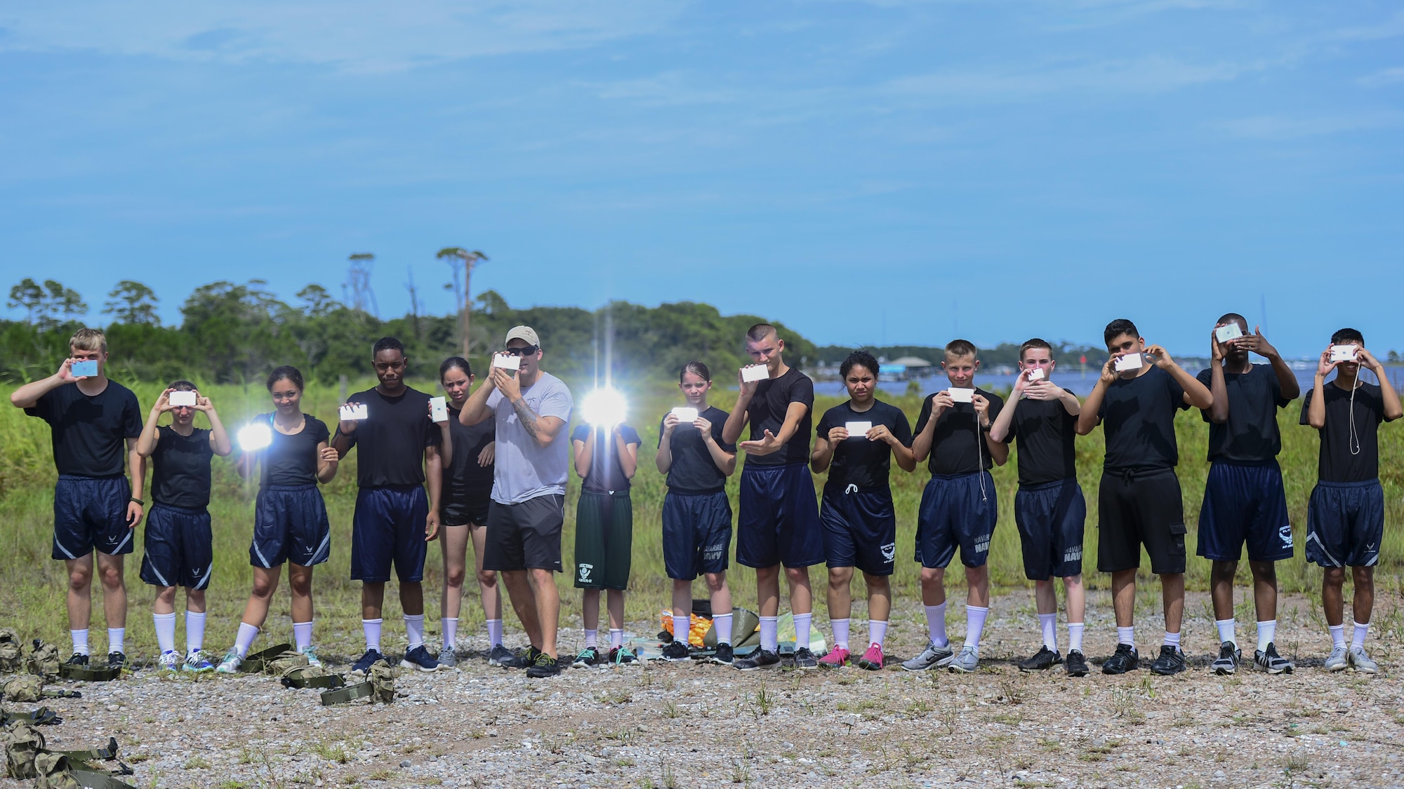 Junior ROTC cadets practice mirror signaling during survival, evasion, resistance and escape training at Hurlburt Field, Fla., June 29, 2017. SERE specialists with the 1st Special Operations Support Squadron gave Summer Leadership School cadets a crash course on SERE, including signaling aircraft, starting fires with natural resources, and crafting shelters in the wilderness. (U.S. Air Force photo by Staff Sgt. Victor J. Caputo)