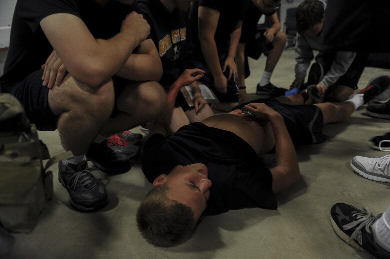 Junior ROTC cadets attempt to diagnose and treat a simulated injury during self-aid and buddy care training at Hurlburt Field, Fla., June 29, 2017. The 1st Special Operations Aerospace Medicine Squadron paired with more than 50 cadets to teach the basics of SABC during a Summer Leadership Course at Hurlburt Field. (U.S. Air Force photo by Airman 1st Class Rachel Yates)