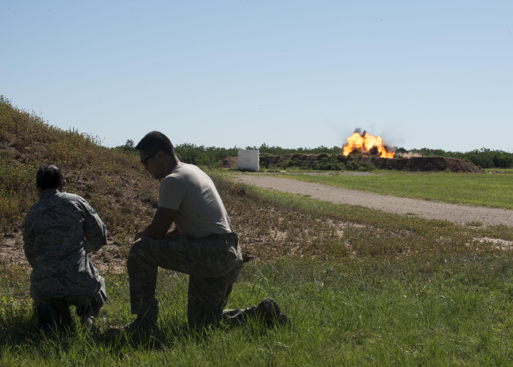 U.S Air Force Senior Airman Jason Jordan (right), 7th Civil Engineer Squadron explosive ordnance disposal journeyman assists an Airman from the 7th Operations Support Squadron (left) in setting off an explosive during a training exercise at Dyess Air Force Base, Texas, June 28, 2017. The EOD team often works closely with other first responders, such as: emergency management, security forces and the fire department to ensure any threats are eliminated. (U.S. Air Force photo by Senior Airman Katherine Miller)