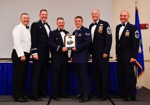 Master Chief Petty Officer Asa Worcester, left, Joint Base Charleston command master chief, Col. Robert Lyman, second from left, Joint Base Charleston wing commander, Col. Patrick Winstead, third from left, 437th Airlift Wing vice commander, Chief Master Sgt. Todd Cole, second from right, Joint Base Charleston command chief,  and Chief Master Sgt. Darrell Amoruso, right, 437th Airlift Wing acting command chief, congratulate Senior Airman Zachary Pforr, middle, 628th Logistics Readiness Squadron member, for earning the John L. Levitow Award during the class 17-E Airman Leadership School Graduation at the Charleston Club here June 29, 2017. The John L. Levitow Award is awarded to a single graduate for every Enlisted Professional Military Education course for demonstrating excellence both as a leader and scholar. 