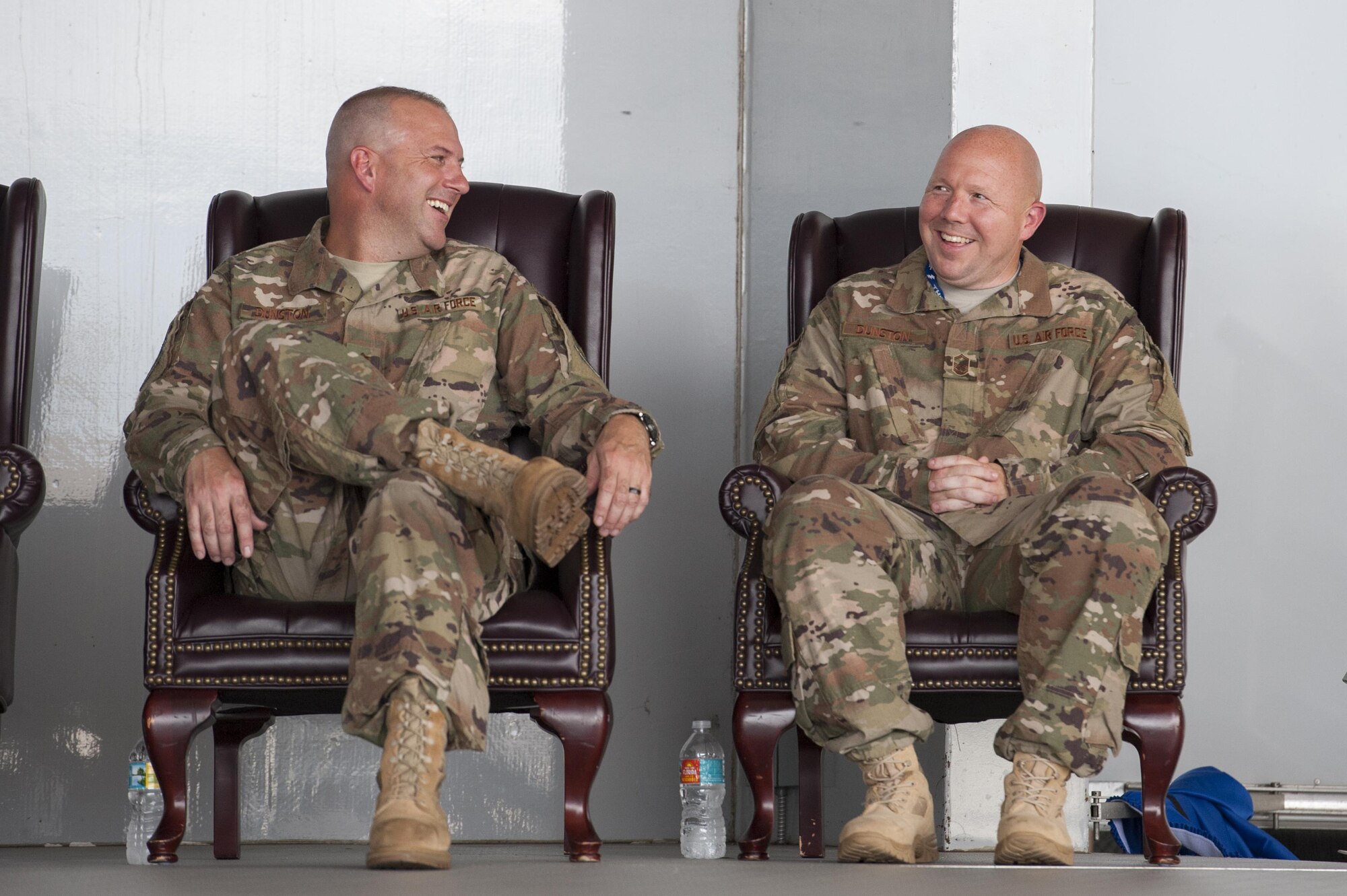 Then Maj. Christopher Dunston, 723d Aircraft Maintenance Squadron commander, left, and then Senior Master Sgt. Brandon Dunston, 74th Aircraft Maintenance Unit superintendent, laugh during a promotion ceremony, June 28, 2017, at Moody Air Force Base, Ga. During the ceremony, Chris promoted to lieutenant colonel and his younger cousin, Brandon, promoted to chief master sergeant. According to Brandon, the pair has been waiting more than 19 years since his day of enlistment to be stationed together. (U.S. Air Force photo by Airman 1st Class Lauren M. Sprunk)
