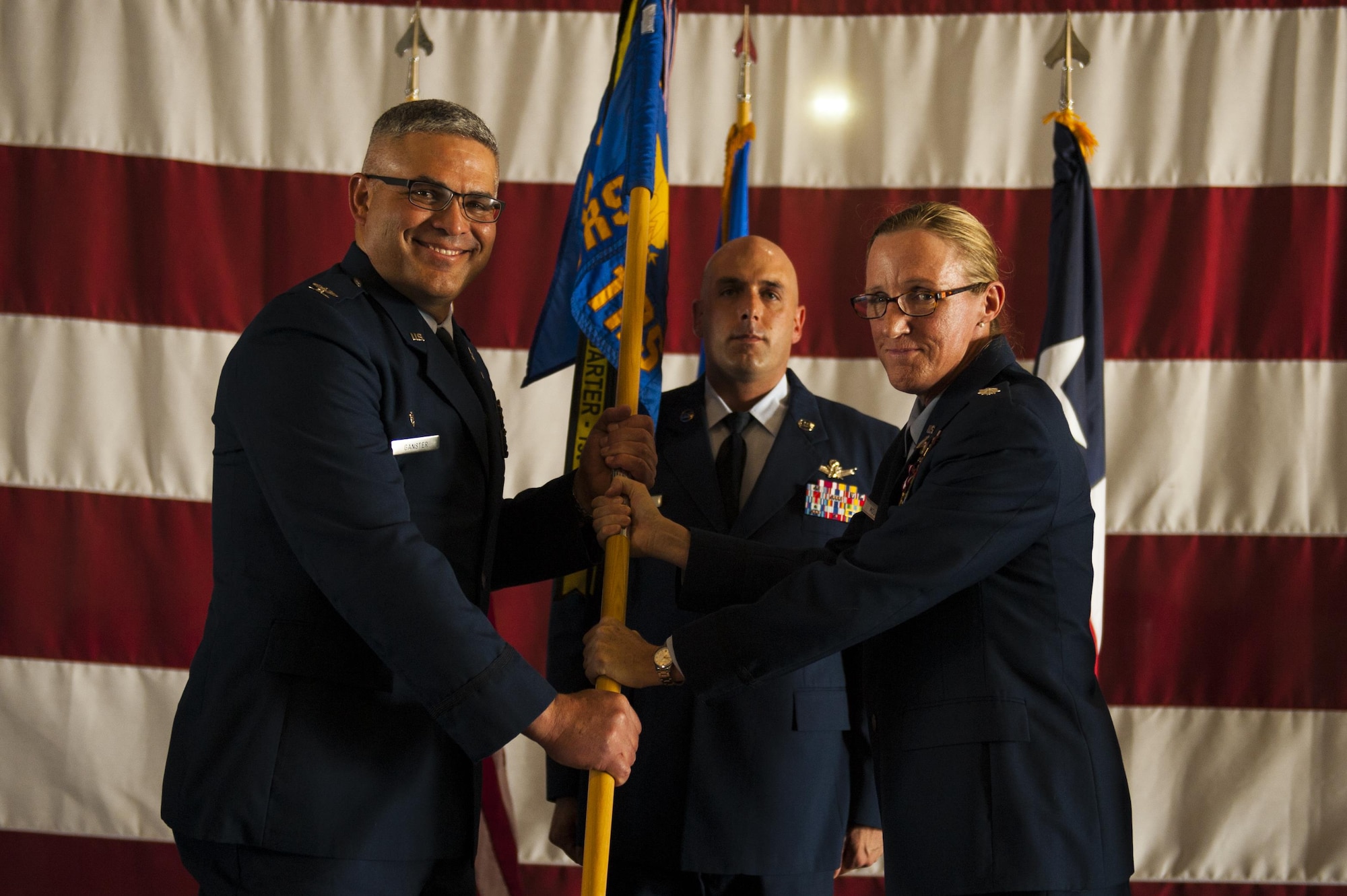 U.S. Air Force Lt. Col. Wendie Mount, prior 316th Training Squadron Commander, passes the unit guideon to Col. Alejandro Ganster, 17th Training Group Commander, during the 316th TRS Change of Command at the Fire Academy high bay on Goodfellow Air Force Base, Texas, June 30, 2017. Mount served as the 316th TRS Commander from 2015 to 2017.  (U.S. Air Force photo by Senior Airman Scott Jackson/Released)