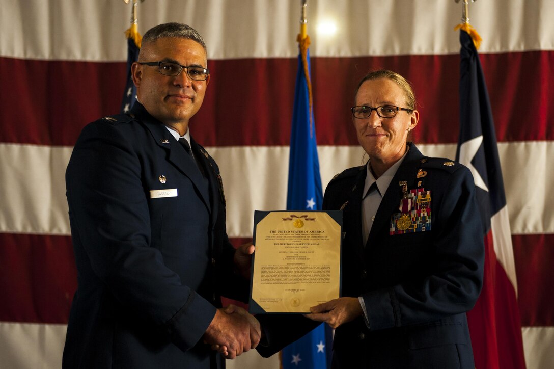 U.S. Air Force Col. Alejandro Ganster, 17th Training Group Commander, awards Lt. Col. Wendie Mount the Air Force Meritorious Service 5th oak leaf cluster medal during the 316th TRS Change of Command ceremony at the Fire Academy high bay on Goodfellow Air Force Base, Texas, June 30, 2017. Mount served as the 316th TRS Commander from 2015 to 2017.  (U.S. Air Force photo by Senior Airman Scott Jackson/Released)